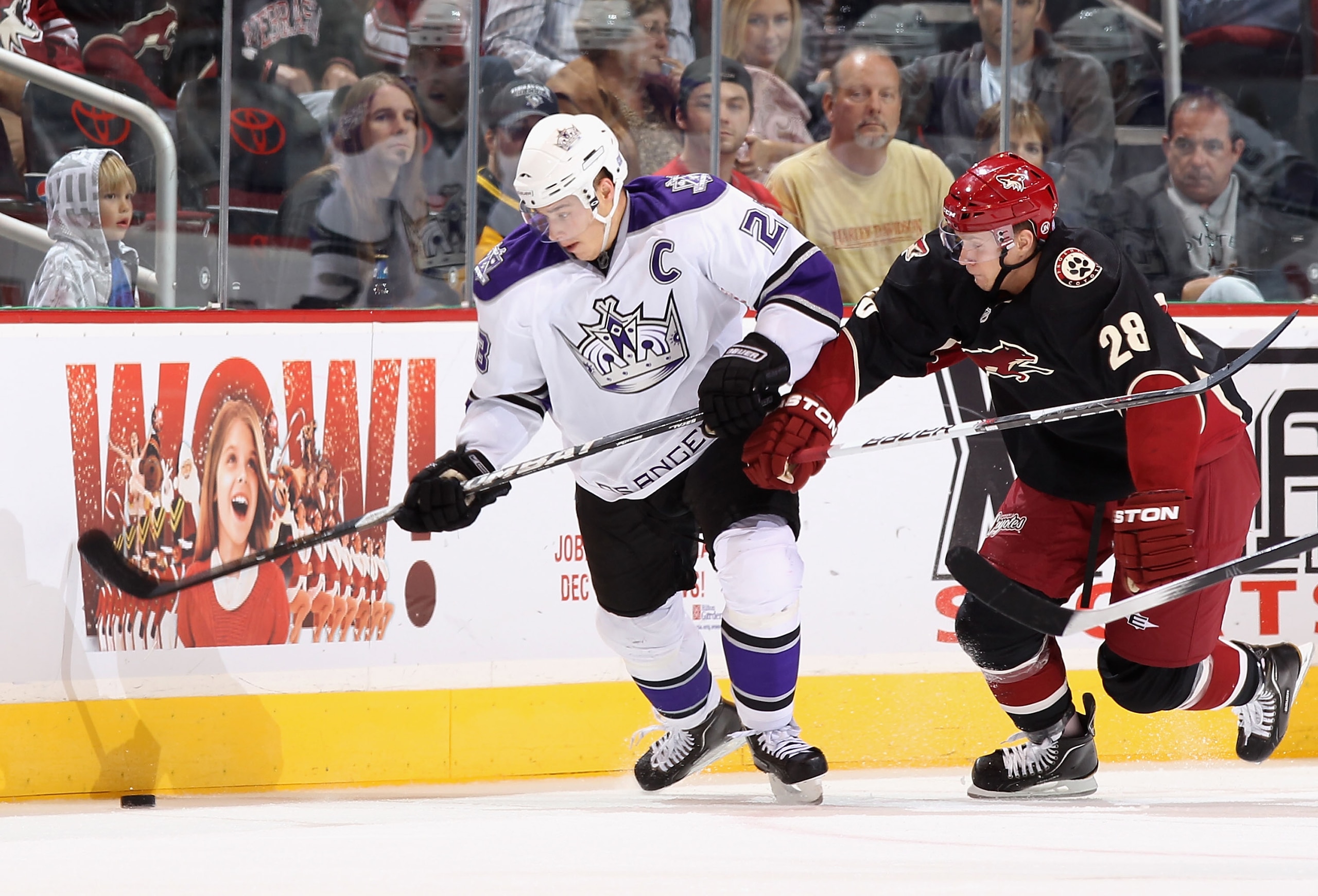GLENDALE, AZ - OCTOBER 21:  Dustin Brown #23 of the Los Angeles Kings skates with the puck past Lauri Korpikoski #28 of the Phoenix Coyotes during the NHL game at Jobing.com Arena on October 21, 2010 in Glendale, Arizona.  The Coyotes defeated the Kings 4