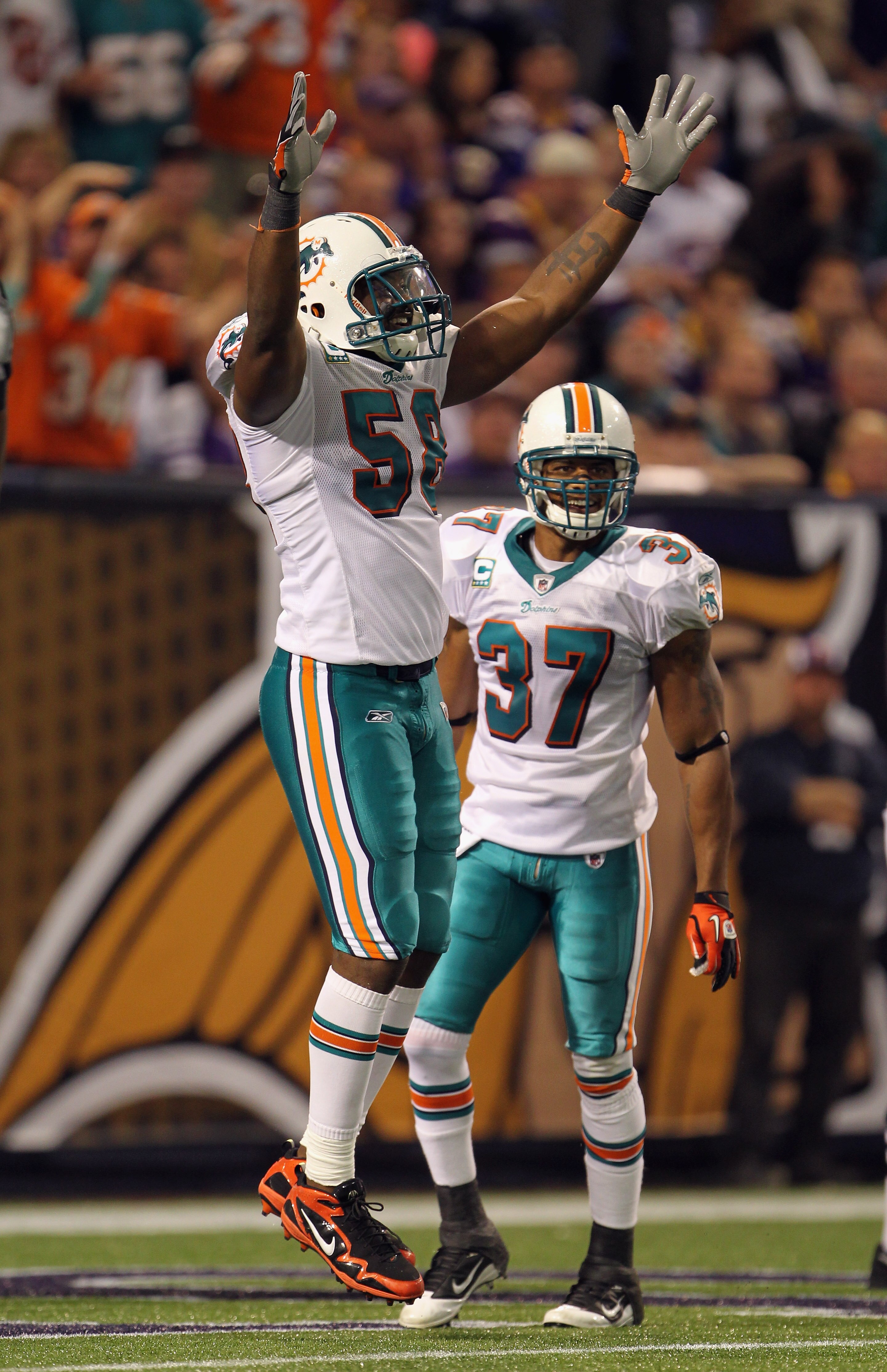 MINNEAPOLIS - SEPTEMBER 19:  Karlos Dansby #58 of the Miami Dolphins celebrates with Yeremiah Bell #37 after the Dolphins defense recovered a fumble in the end zone for a touchdown during the game on September 19, 2010 at Hubert H. Humphrey Metrodome in M