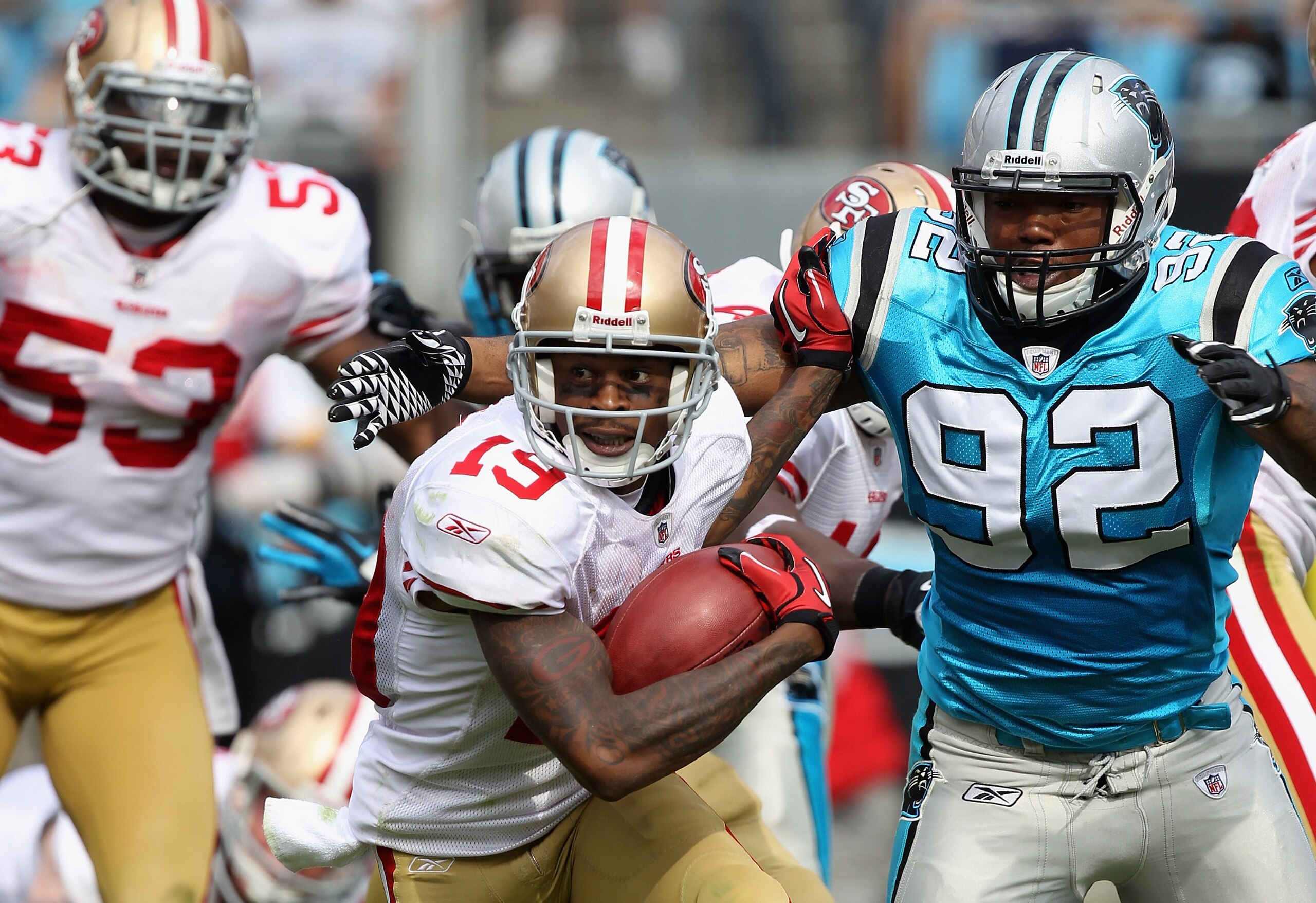 CHARLOTTE, NC - OCTOBER 24:  Ted Ginn #19 of the San Francisco 49ers tries to run away from Eric Norwood #92 of the Carolina Panthers during their game at Bank of America Stadium on October 24, 2010 in Charlotte, North Carolina.  (Photo by Streeter Lecka/
