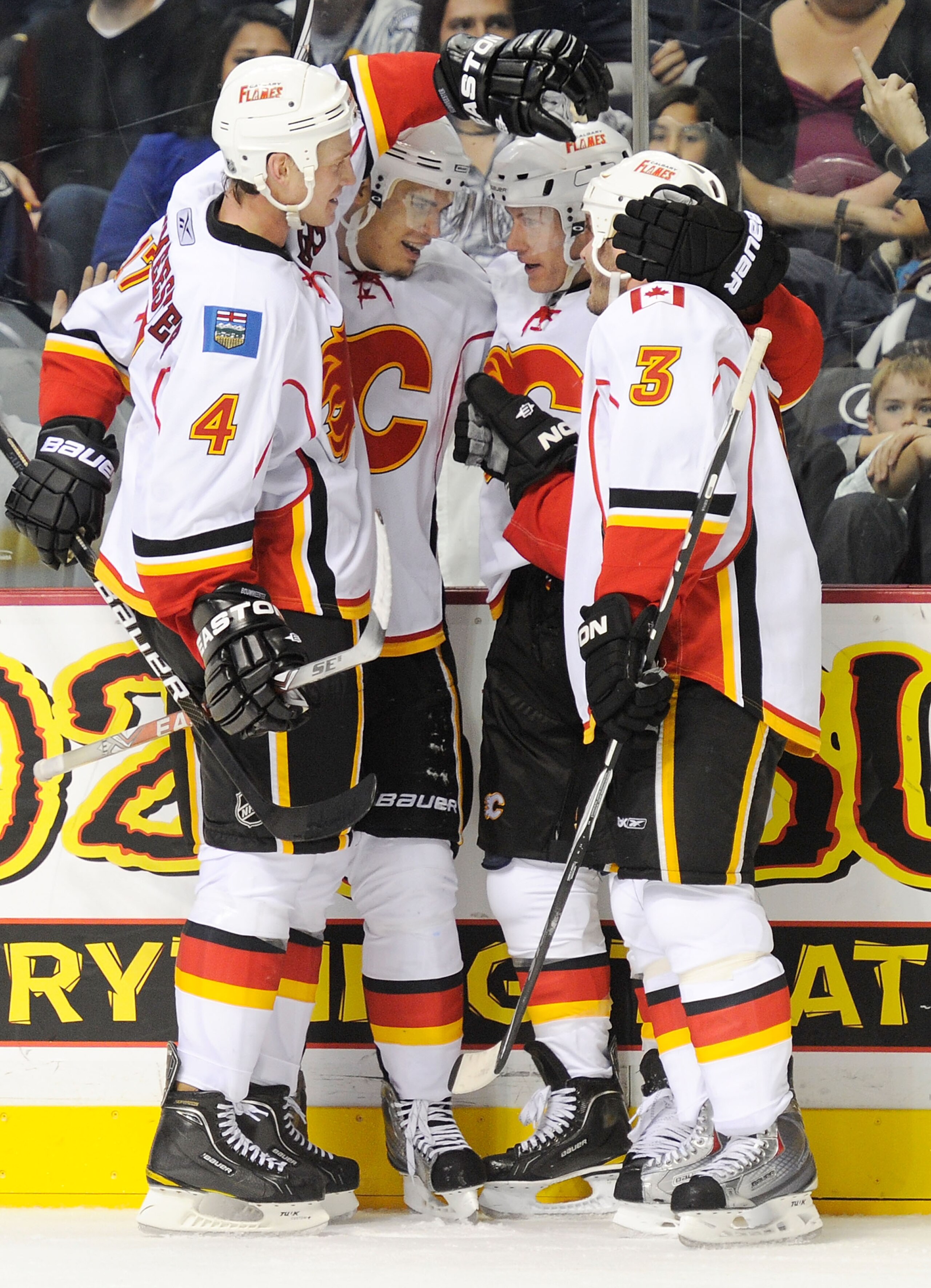 NASHVILLE, TN - OCTOBER 19:  (L-R) Jay Bouwmeester #4, Brendan Morrison, Rene Bourque, and Ian White #3 of the Calgary Flames celebrate defeating the Nashville Predators in overtime on October 19, 2010 in Nashville, Tennessee.  (Photo by Frederick Breedon