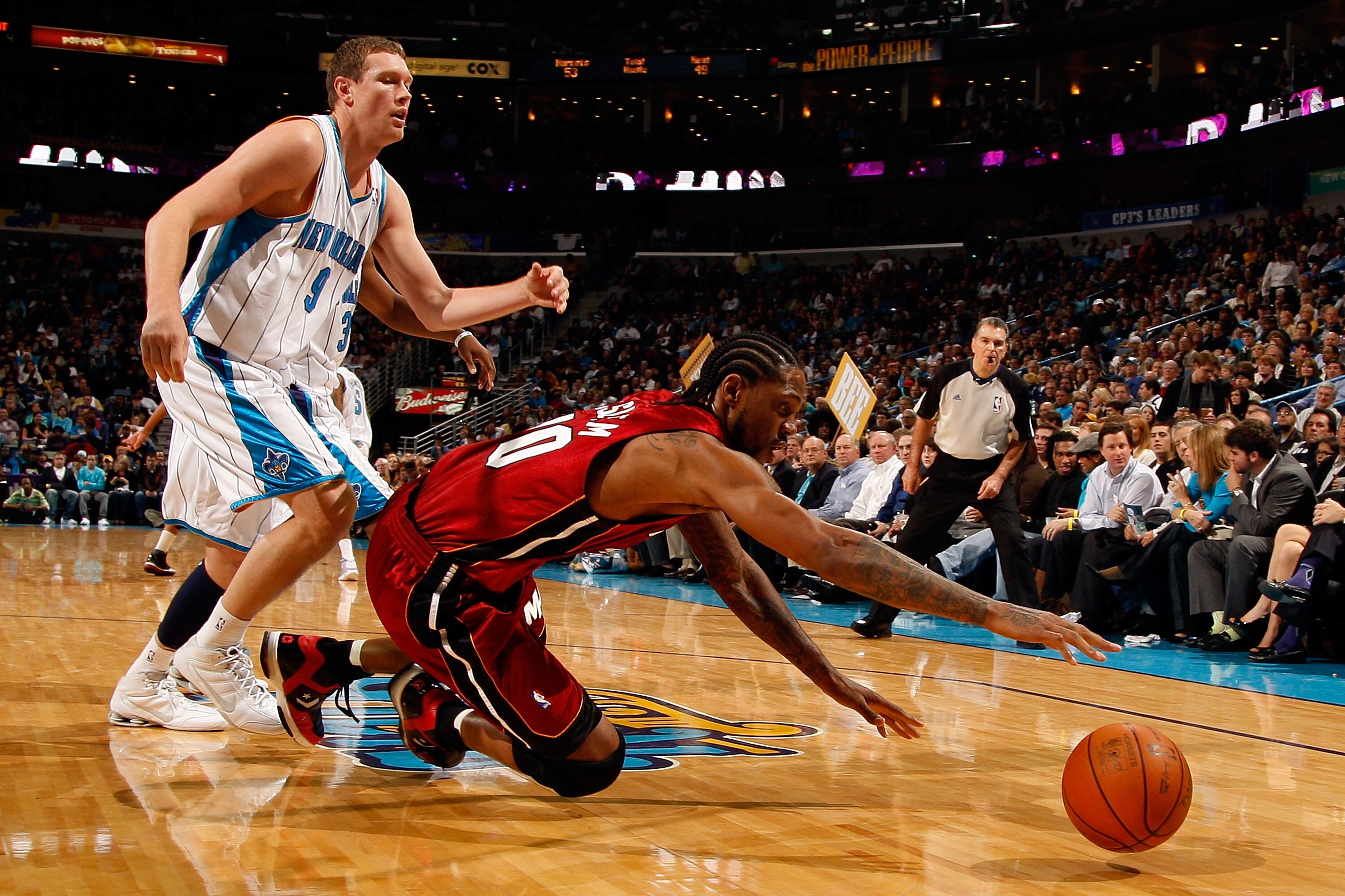 NEW ORLEANS - DECEMBER 30:  Udonis Haslem #40 of the Miami Heat dives for a lose ball around Daris Songaila #9 of the New Orleans Hornets at New Orleans Arena on December 30, 2009 in New Orleans, Louisiana.  The Hornets defeated the Heat 95-91.  NOTE TO U