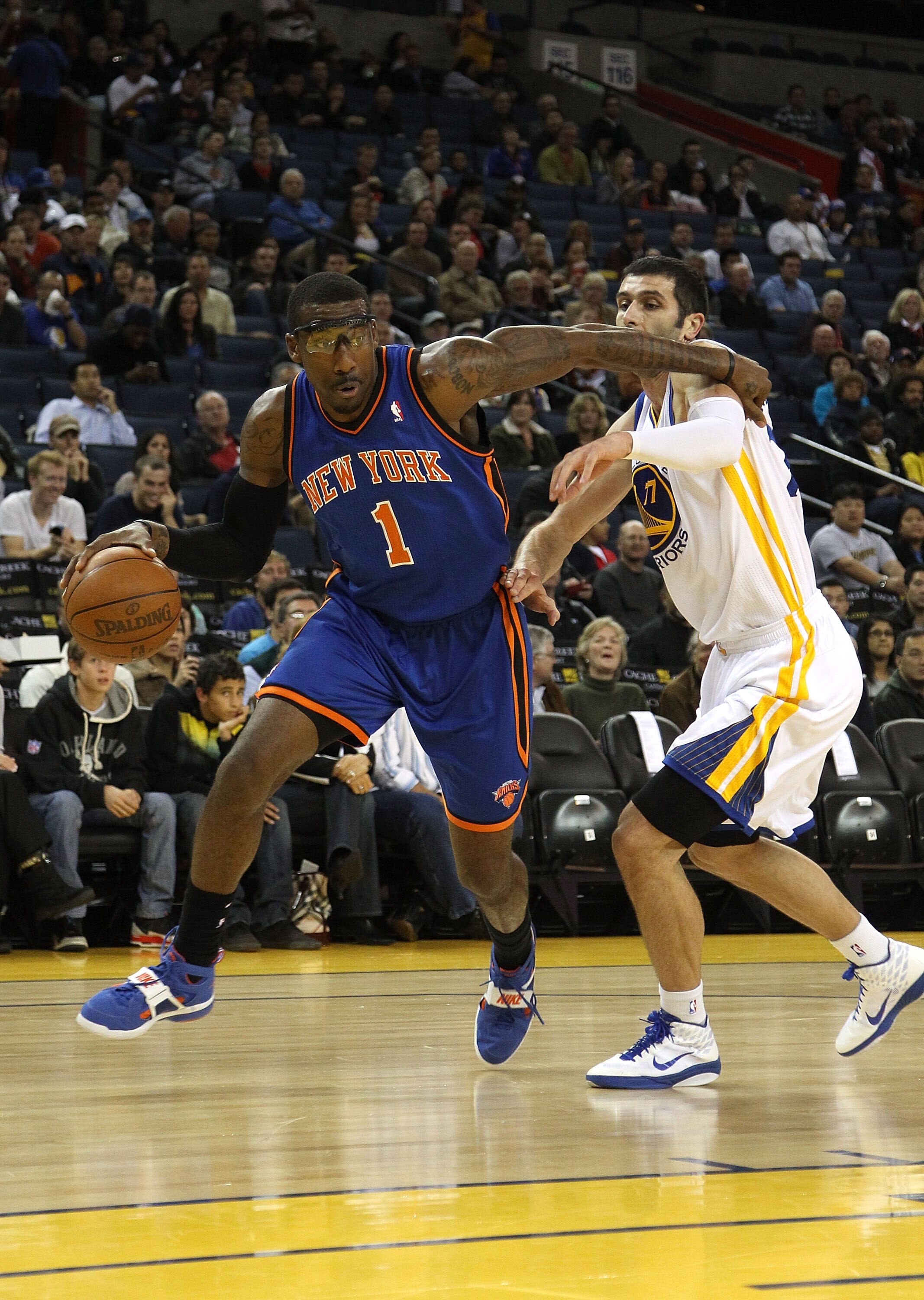 OAKLAND, CA - NOVEMBER 19:  Amar'e Stoudemire #1 of the New York Knicks dribbles past Vladimir Radmanovic #77 of the Golden State Warriors at Oracle Arena on November 19, 2010 in Oakland, California. NOTE TO USER: User expressly acknowledges and agrees th
