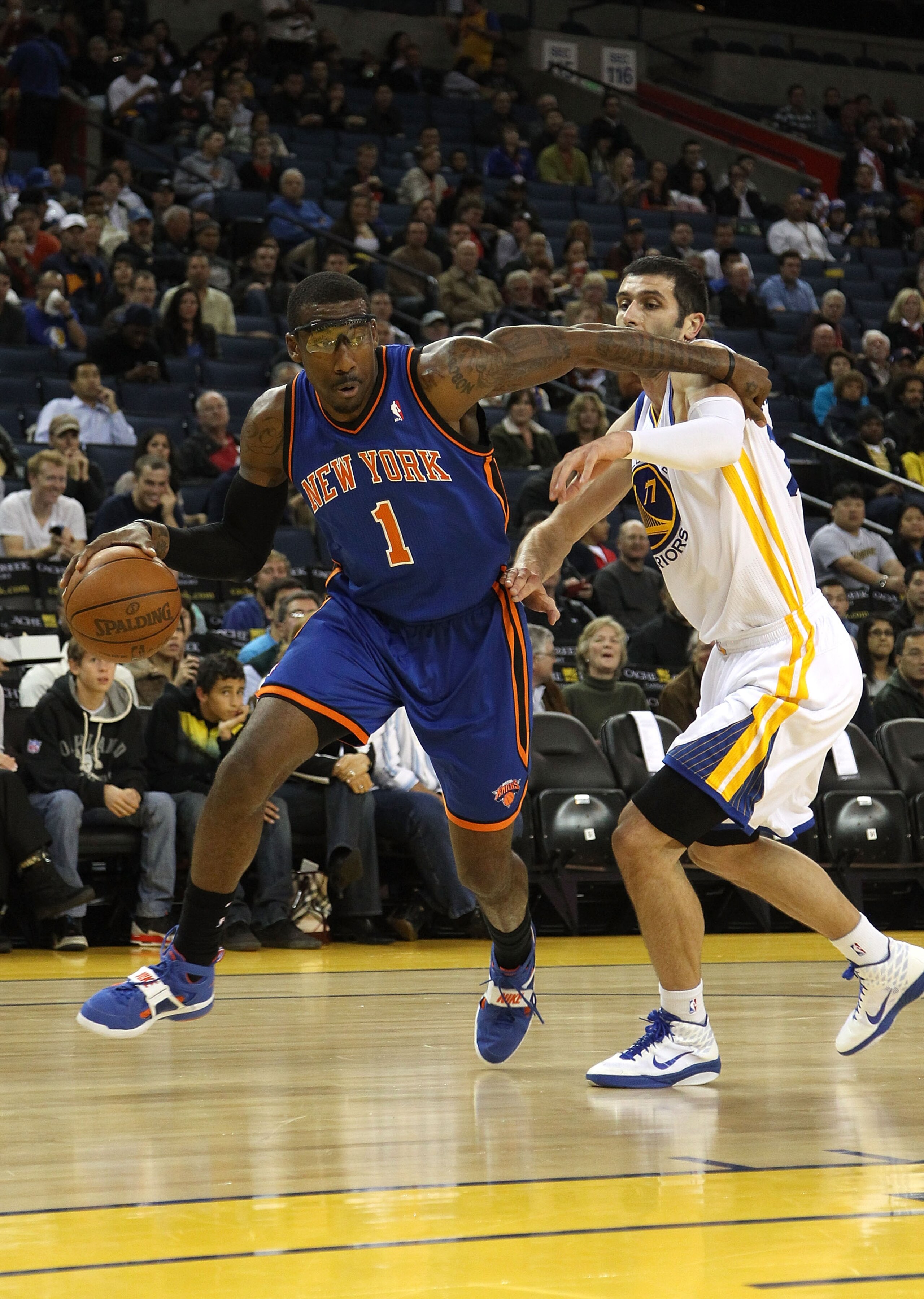 OAKLAND, CA - NOVEMBER 19:  Amar'e Stoudemire #1 of the New York Knicks dribbles past Vladimir Radmanovic #77 of the Golden State Warriors at Oracle Arena on November 19, 2010 in Oakland, California. NOTE TO USER: User expressly acknowledges and agrees th