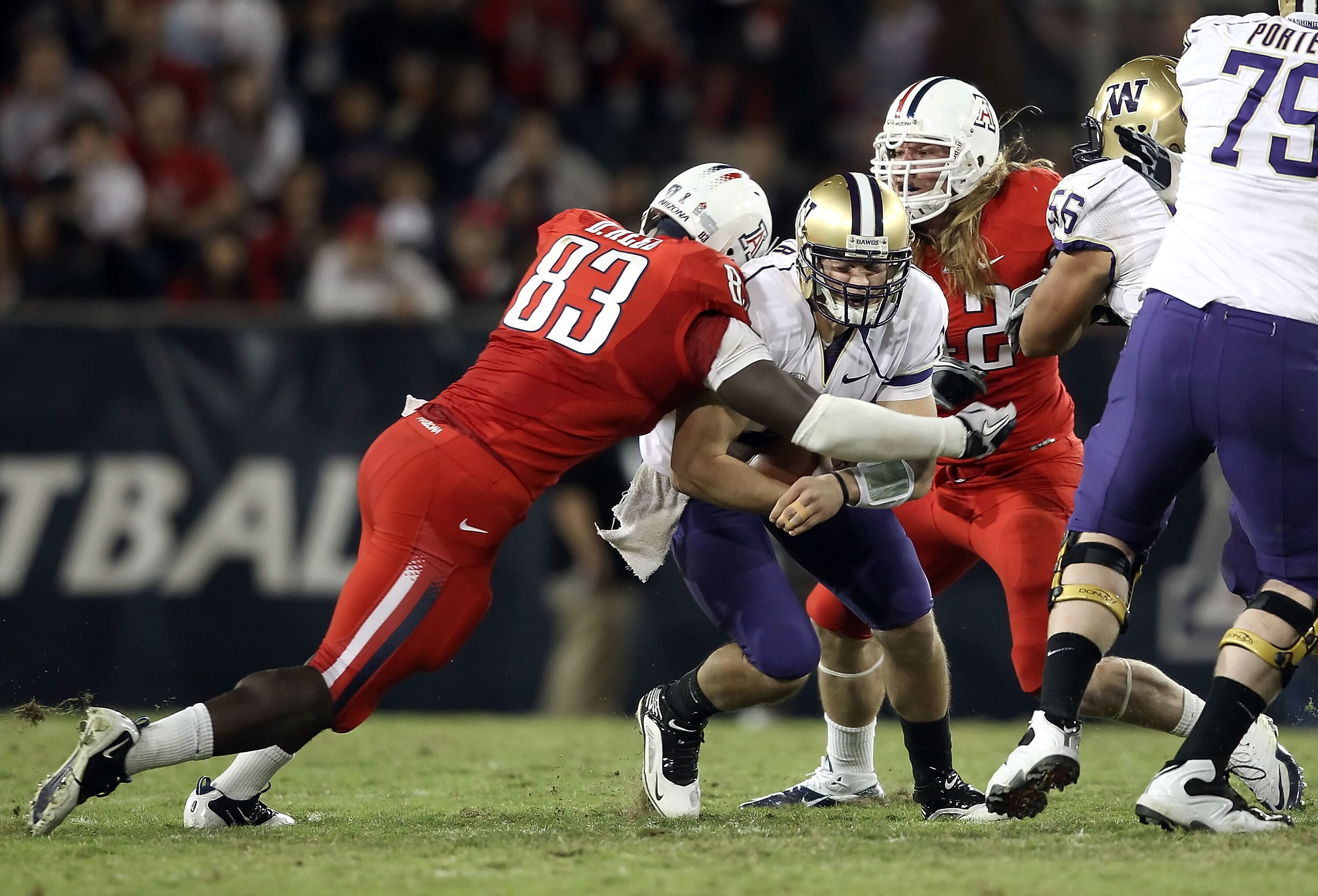 TUCSON, AZ - OCTOBER 23:  Quarterback Jake Locker #10 of the Washington Huskies is tackled by  D'Aundre Reed #83 of the Arizona Wildcats during the college football game at Arizona Stadium on October 23, 2010 in Tucson, Arizona.  (Photo by Christian Peter