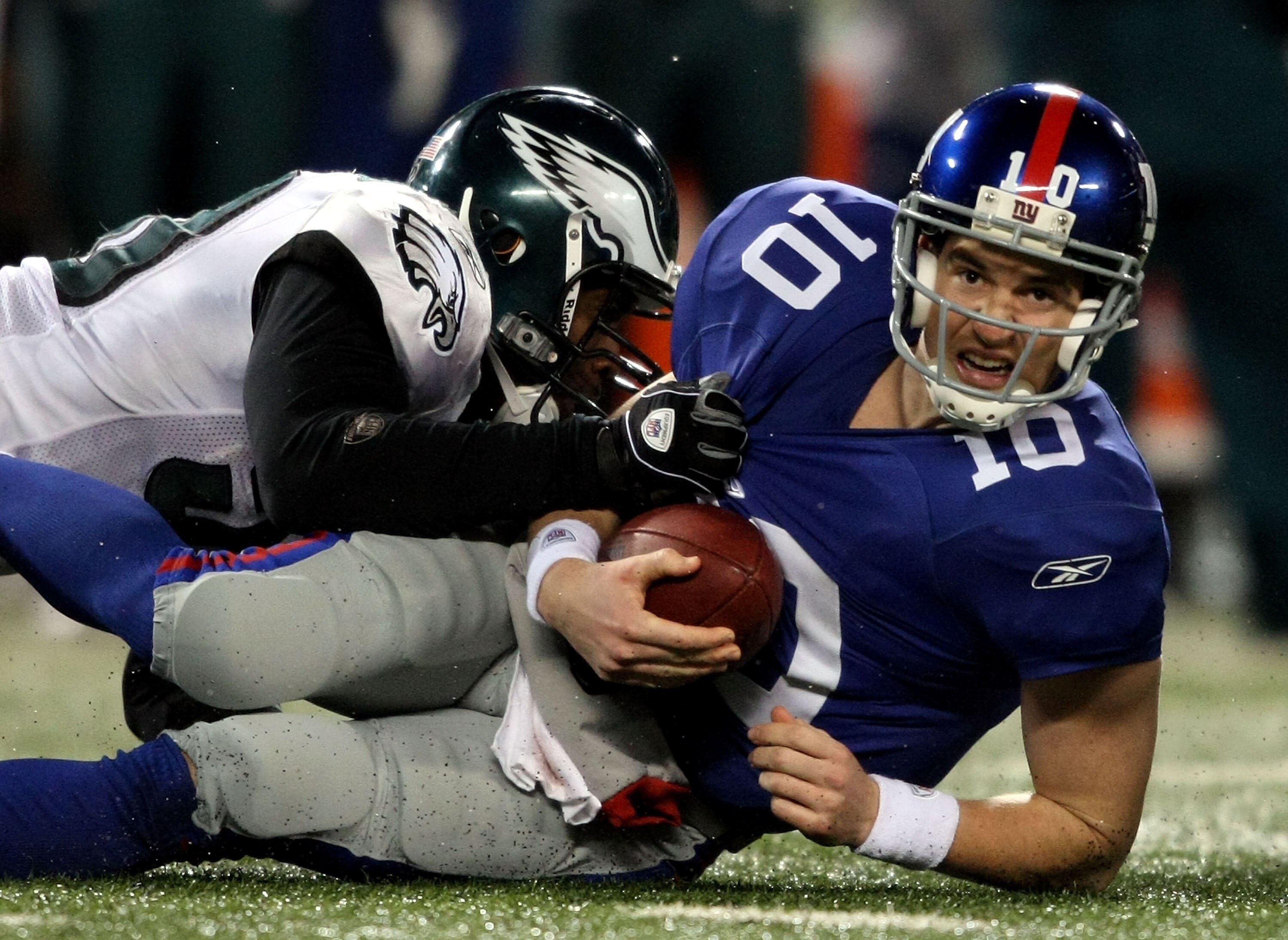 EAST RUTHERFORD, NJ - DECEMBER 13:  Eli Manning #10 of the New York Giants gets sacked late in the game by Will Witherspoon #50 of the Philadelphia Eagles at Giants Stadium on December 13, 2009 in East Rutherford, New Jersey.  (Photo by Nick Laham/Getty I