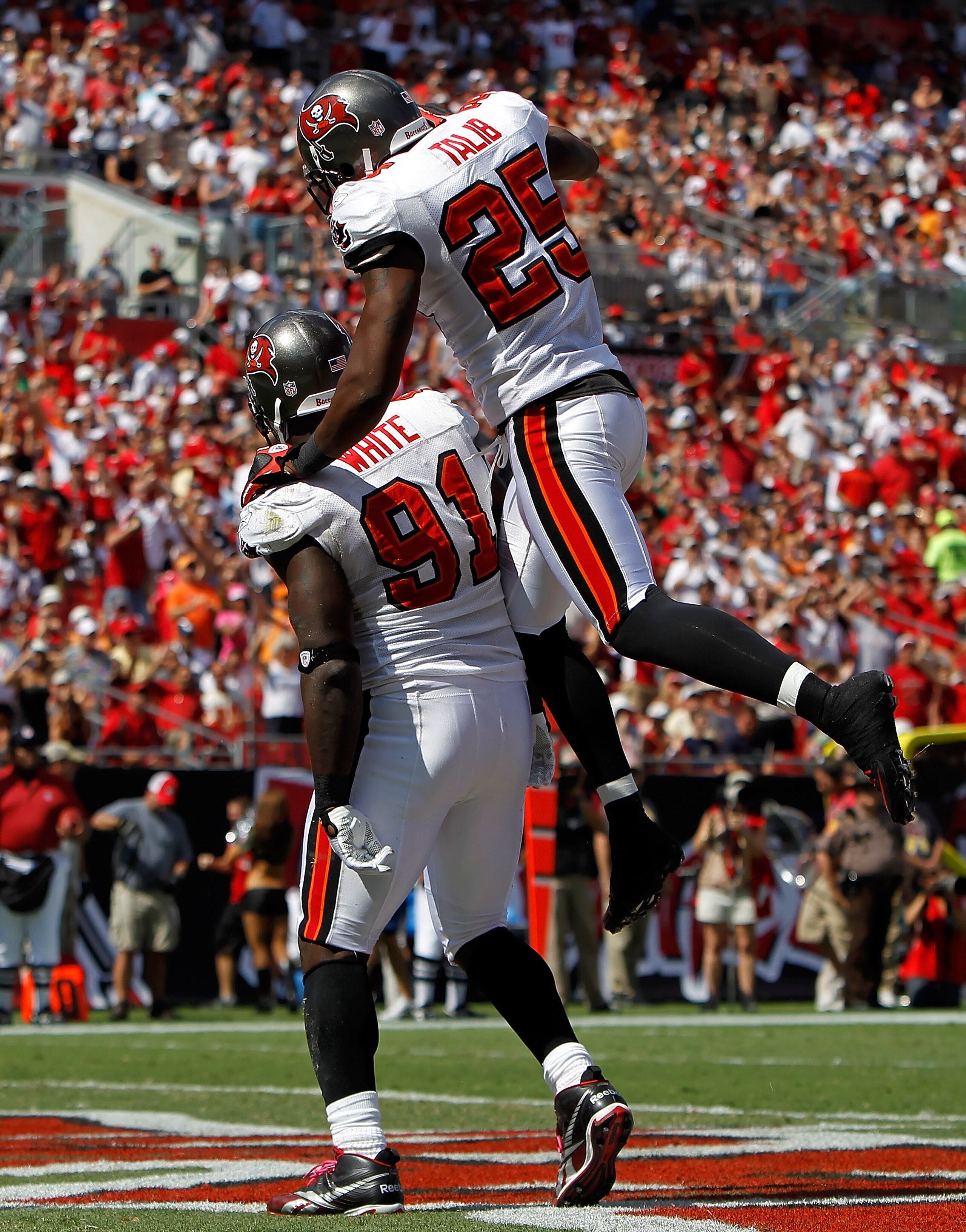 TAMPA, FL - OCTOBER 24:  Defenders Stylz G. White #91 and Aqib Talib #25 of the Tampa Bay Buccaneers celebrate White's sack against the St. Louis Rams during the game at Raymond James Stadium on October 24, 2010 in Tampa, Florida.  (Photo by J. Meric/Gett