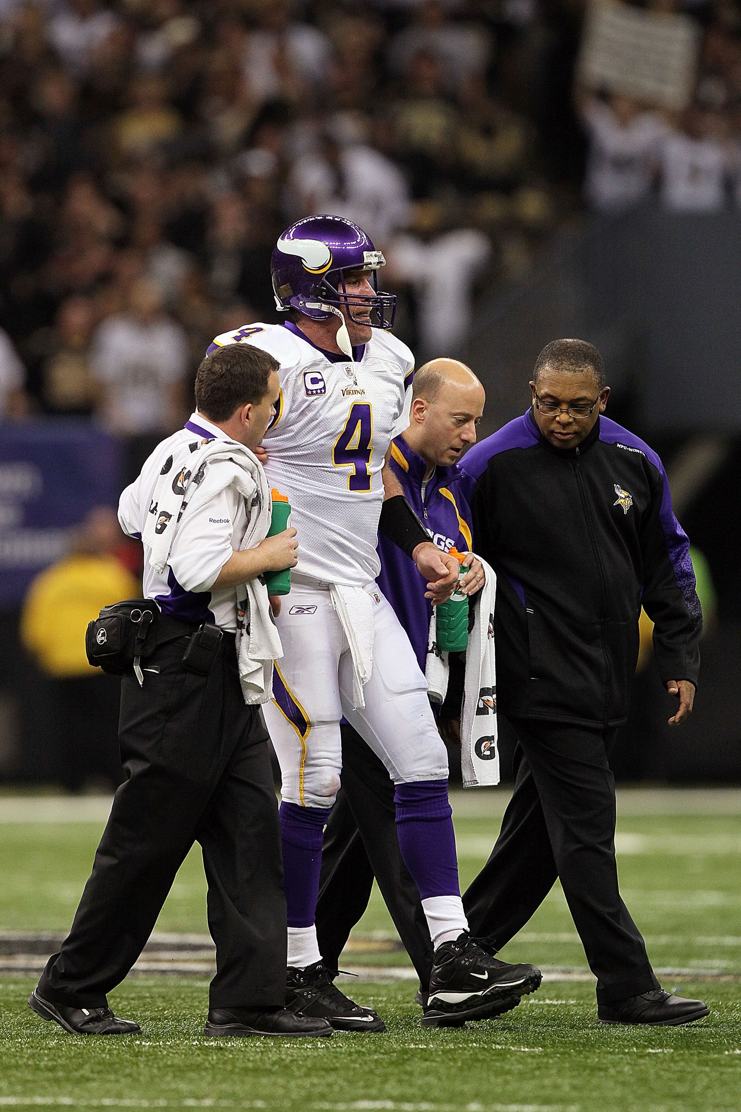 NEW ORLEANS - JANUARY 24: Brett Favre #4 of the Minnesota Vikings is helped off the field by medical staff after getting injured on a play against the New Orleans Saints during the NFC Championship Game at the Louisiana Superdome on January 24, 2010 in NEW ORLEANS - JANUARY 24: Brett Favre #4 of the Minnesota Vikings is helped off the field by medical staff after getting injured on a play against the New Orleans Saints during the NFC Championship Game at the Louisiana Superdome on January 24, 2010 in