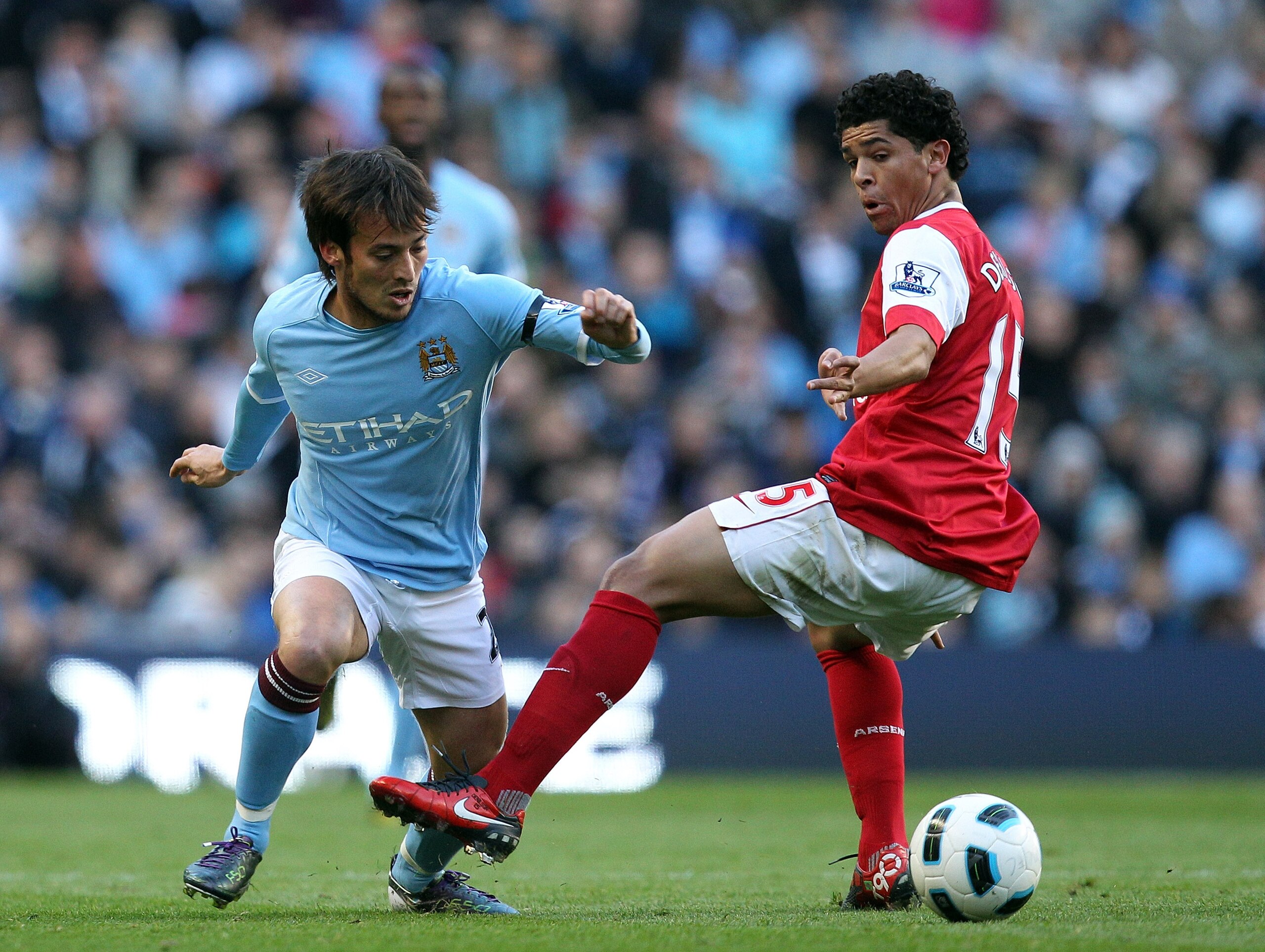 MANCHESTER, ENGLAND - OCTOBER 24:  David Silva of City goes past Denilson of Arsenal during the Barclays Premier League match between Manchester City and Arsenal at City of Manchester Stadium on October 24, 2010 in Manchester, England.  (Photo by Richard