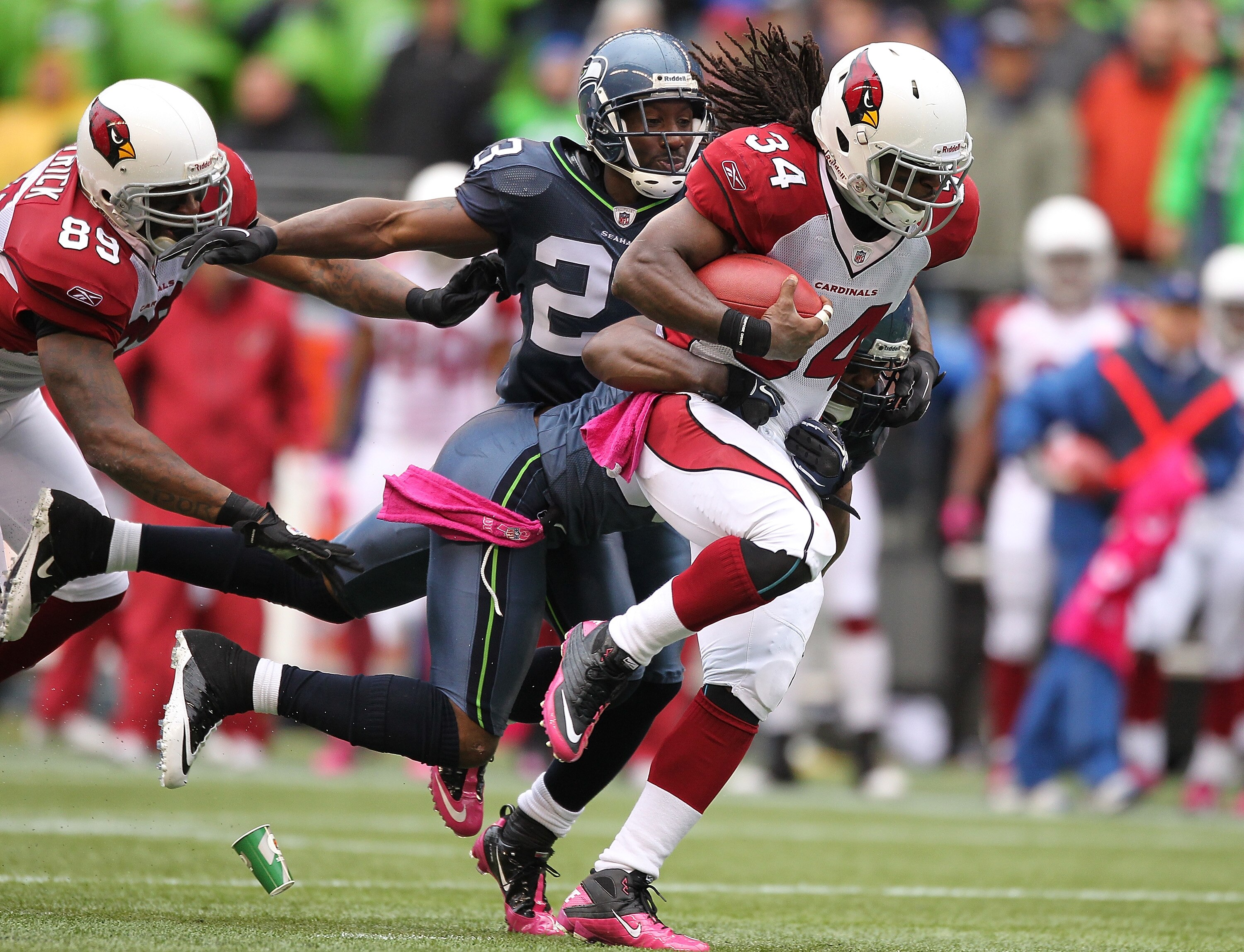 SEATTLE - OCTOBER 24:  Running back Tim Hightower #34 of the Arizona Cardinals rushes against Marcus Trufant #23 and Lawyer Milloy #36 of the Seattle Seahawks at Qwest Field on October 24, 2010 in Seattle, Washington. The Seahawks defeated the Cardinals 2