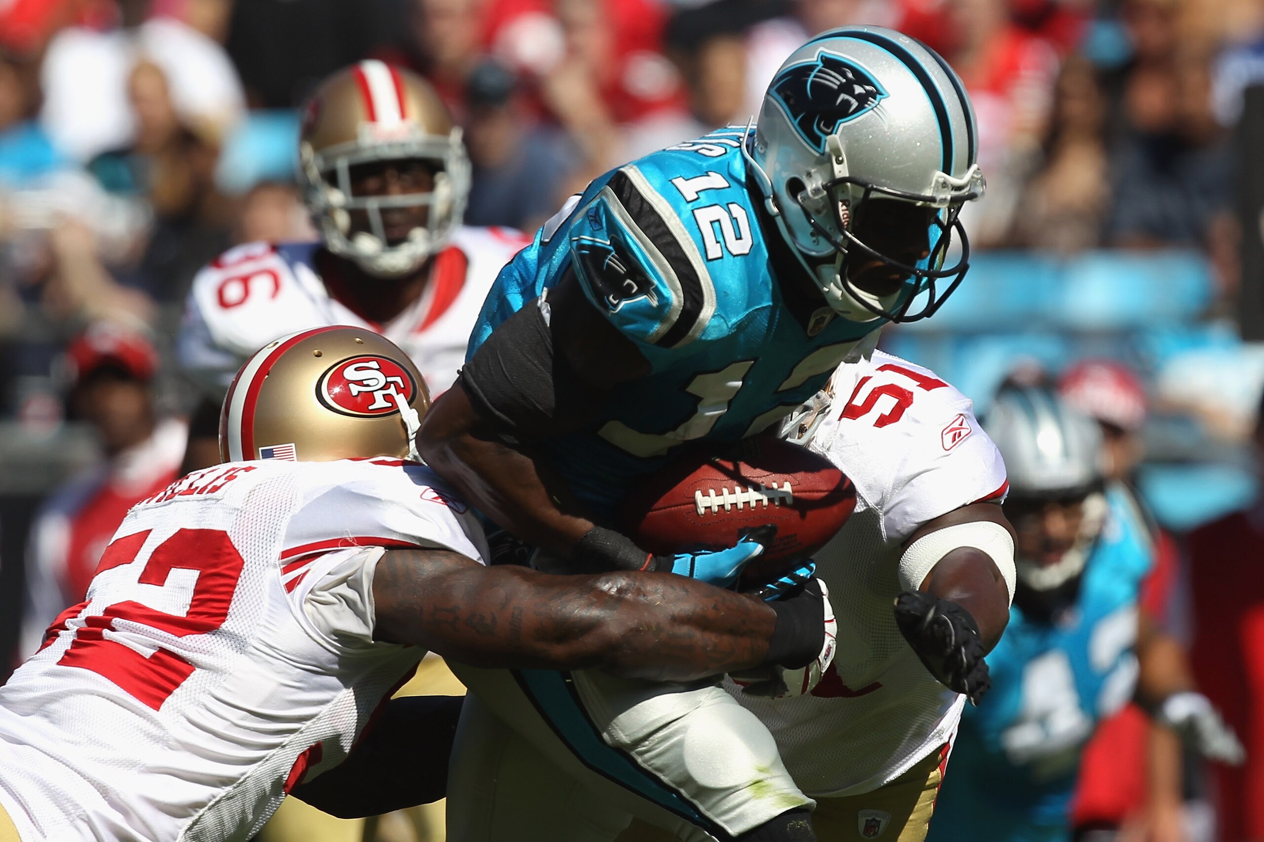 CHARLOTTE, NC - OCTOBER 24:  Teammates Patrick Willis #52 and Takeo Spikes #51 of the San Francisco 49ers tackle David Gettis #12 of the Carolina Panthers during their game at Bank of America Stadium on October 24, 2010 in Charlotte, North Carolina.  (Pho