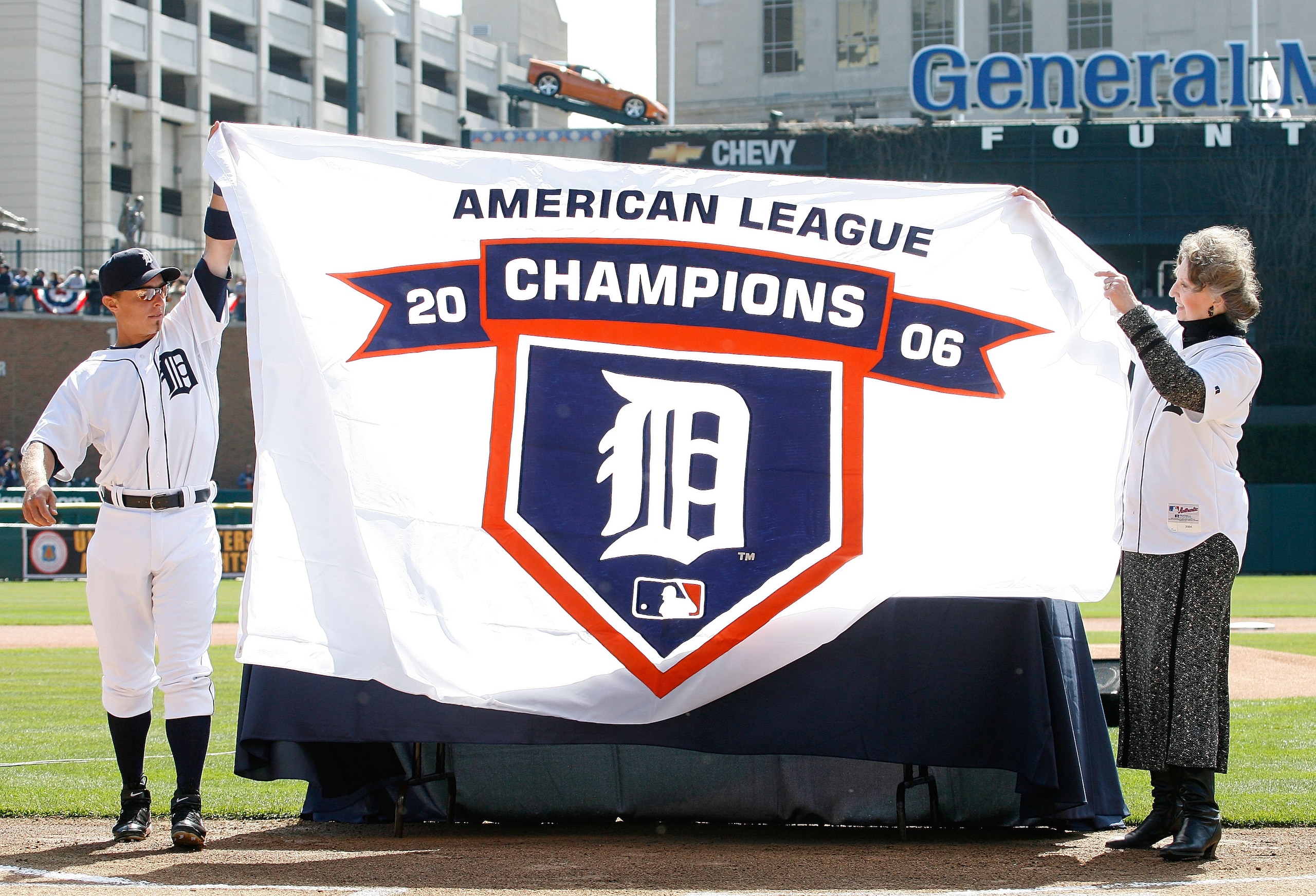 DETROIT - APRIL 02:  Administrative Assistant, Public Affairs Audrey Zielinski (R) and Brandon Inge #15 of the Detroit Tigers hold up a replica of the Tigers 2006 American League Championship Banner prior to their home opener against the Toronto Blue Jays