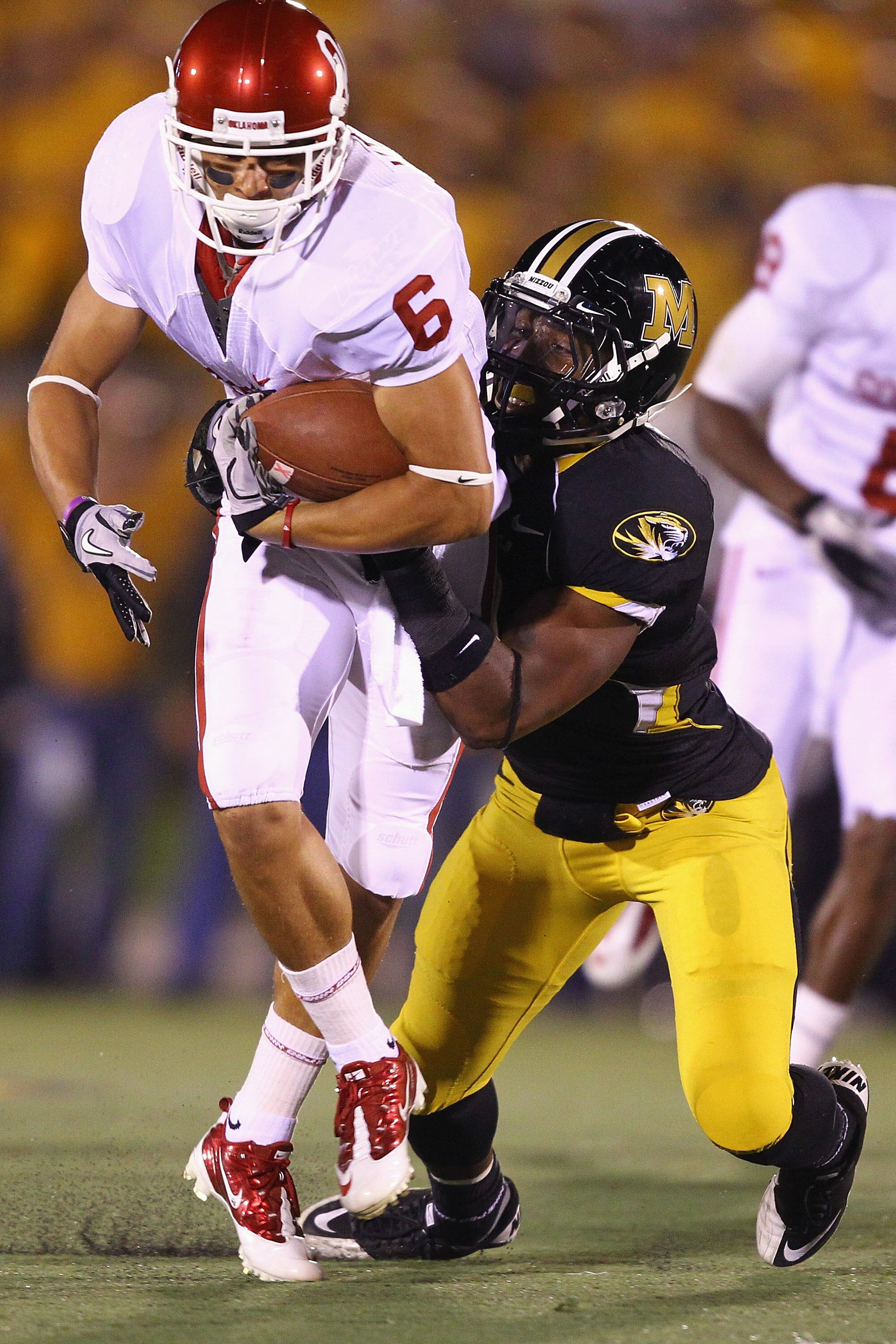 COLUMBIA, MISSOURI - OCTOBER 23: Cameron Kenney #6 of the Oklahoma Sooners is tackled by Jasper Simmons #9 of the Missouri Tigers at Faurot Field/Memorial Stadium on October 23, 2010 in Columbia, Missouri.  (Photo by Dilip Vishwanat/Getty Images)
