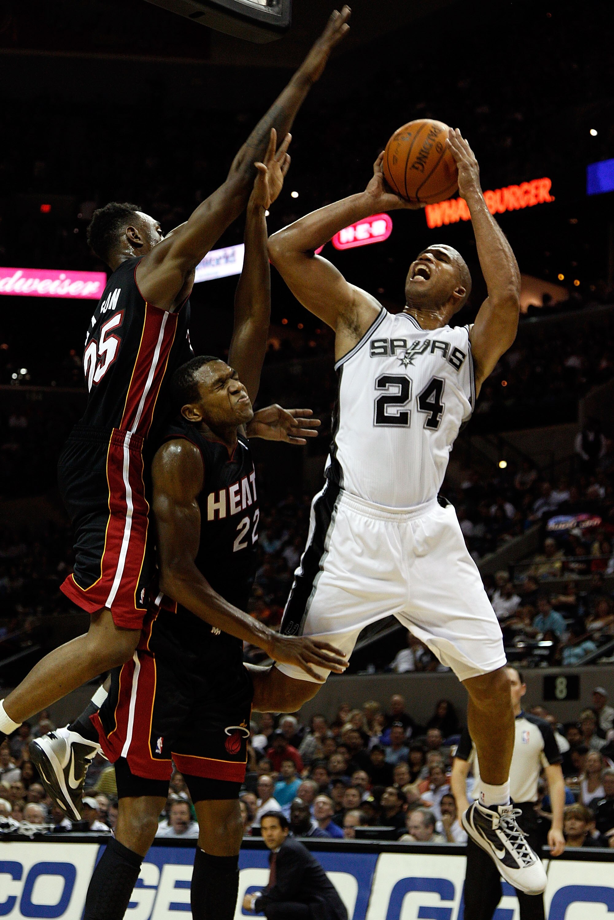 SAN ANTONIO - OCTOBER 09:  Richard Jefferson #24 of the San Antonio Spurs makes a shot over James Jones #22 and Anthony Mason #25 of the Miami Heat at the AT&T Center on October 9, 2010 in San Antonio, Texas.  NOTE TO USER: User expressly acknowledges and