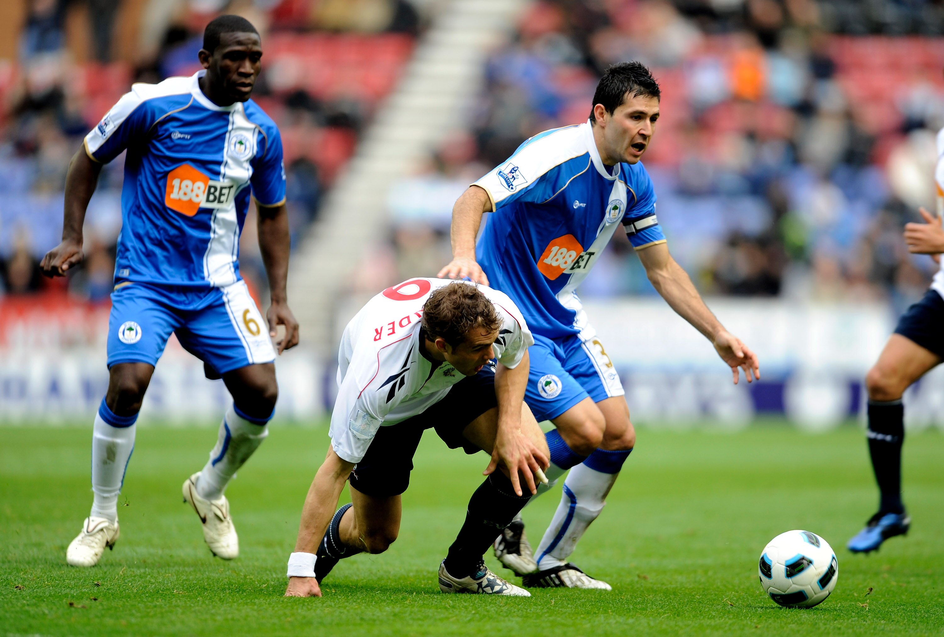 WIGAN, ENGLAND - OCTOBER 23:  Johan Elmander of Bolton Wanderers tangles with Antolin Alcaraz of Wigan Athletic during the Barclays Premier League match between Wigan Athletic and Bolton Wanderers at the DW Stadium on October 23, 2010 in Wigan, England.