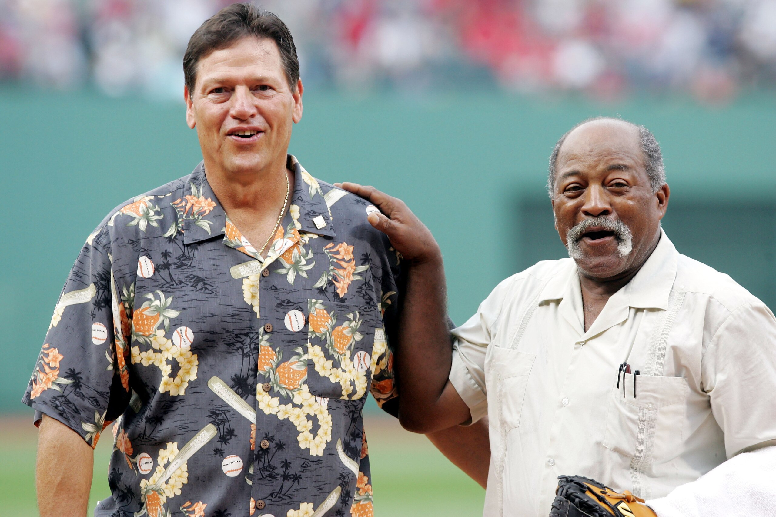 BOSTON, MA - JUNE 13: Former Boston Red Sox legends Carlton Fisk (L) and Luis Tiant walk off the field after Fisk threw out the first pitch to Tiant before the start of the game between the Cincinnati Reds and Red Sox at Fenway Park on June 13, 2005 in Bo