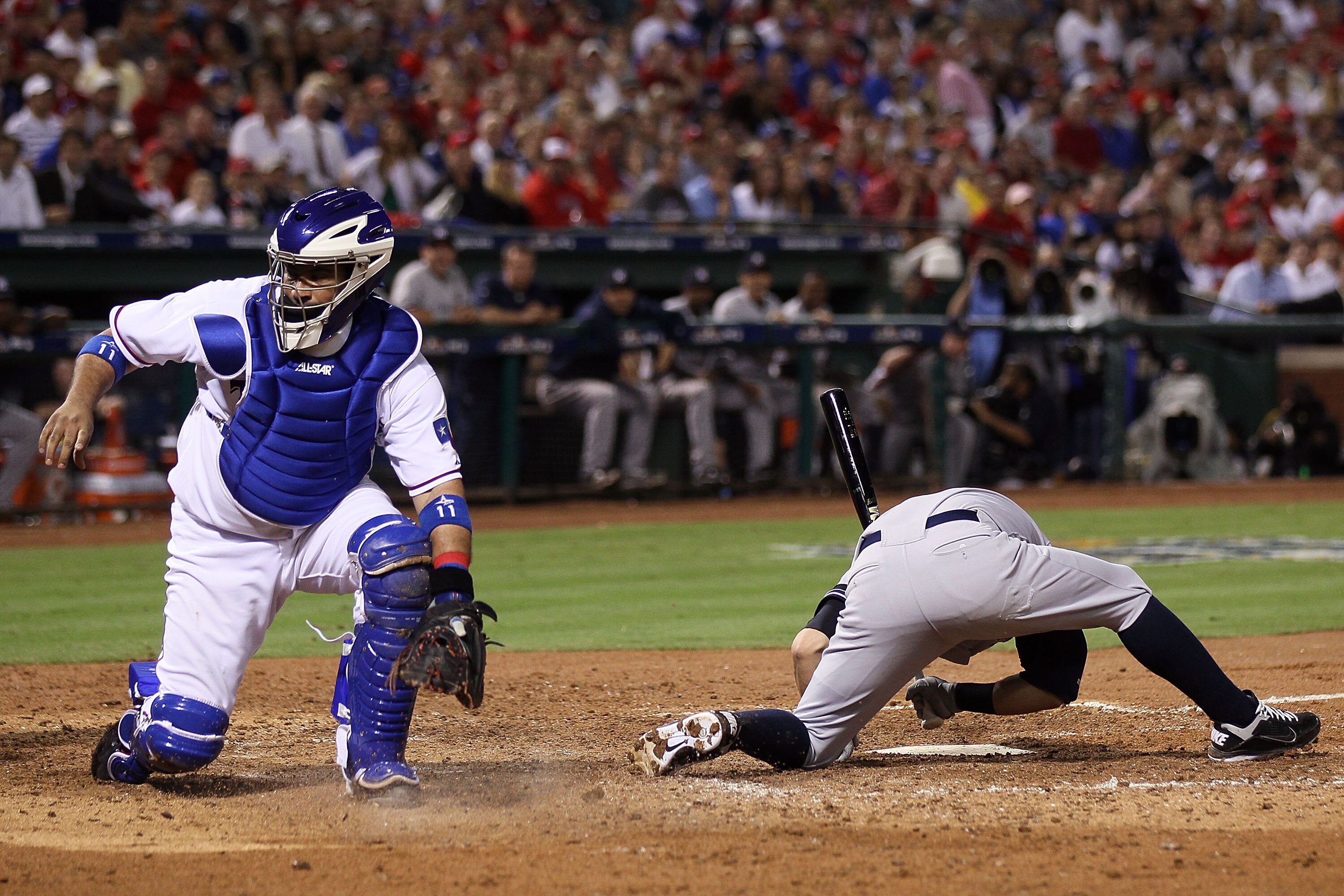 ARLINGTON, TX - OCTOBER 22:  Bengie Molina #11 of the Texas Rangers looks back at a wild pitch from Colby Lewis #48 which allowed Alex Rodriguez #13 of the New York Yankees to score as Nick Swisher #33 picks himself up off the dirt in the fifth inning of