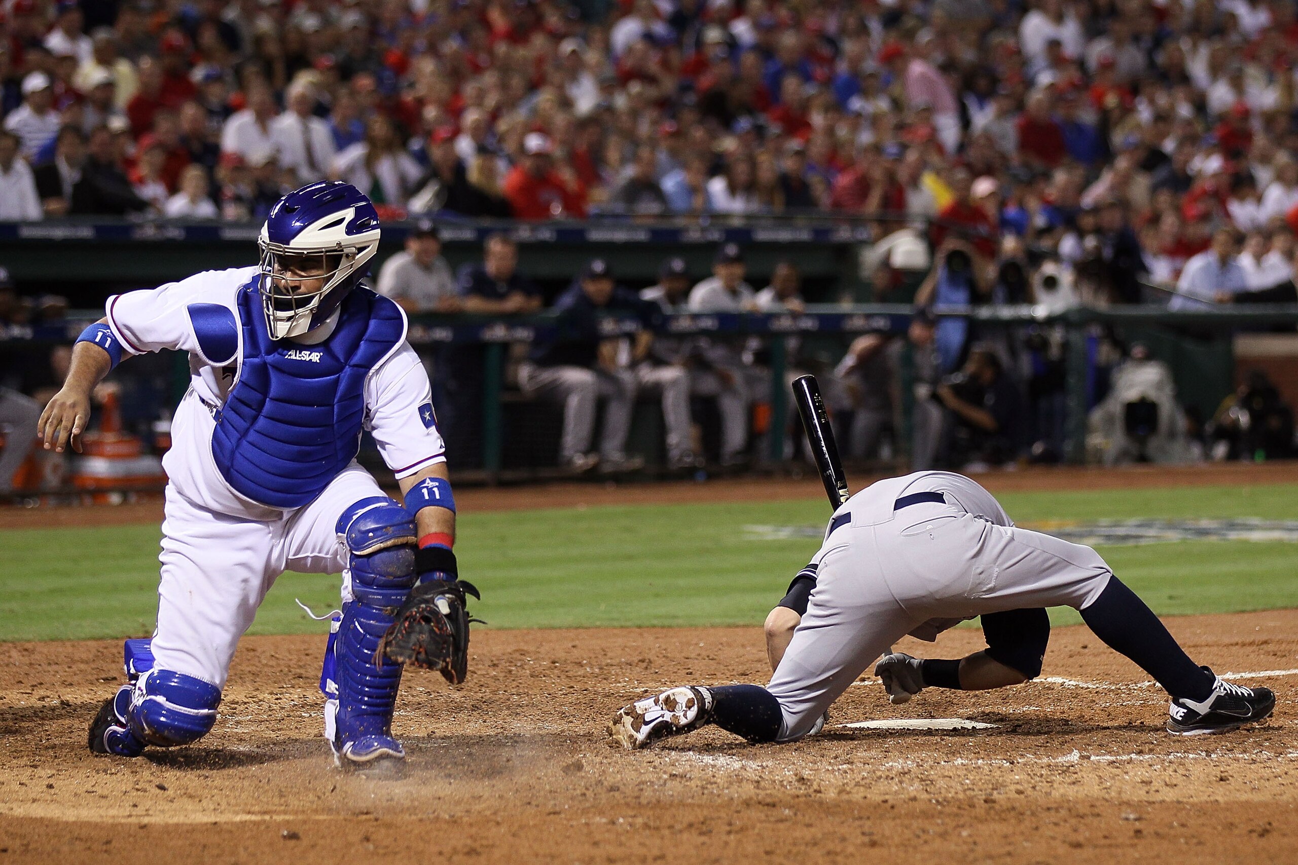 ARLINGTON, TX - OCTOBER 22:  Bengie Molina #11 of the Texas Rangers looks back at a wild pitch from Colby Lewis #48 which allowed Alex Rodriguez #13 of the New York Yankees to score as Nick Swisher #33 picks himself up off the dirt in the fifth inning of