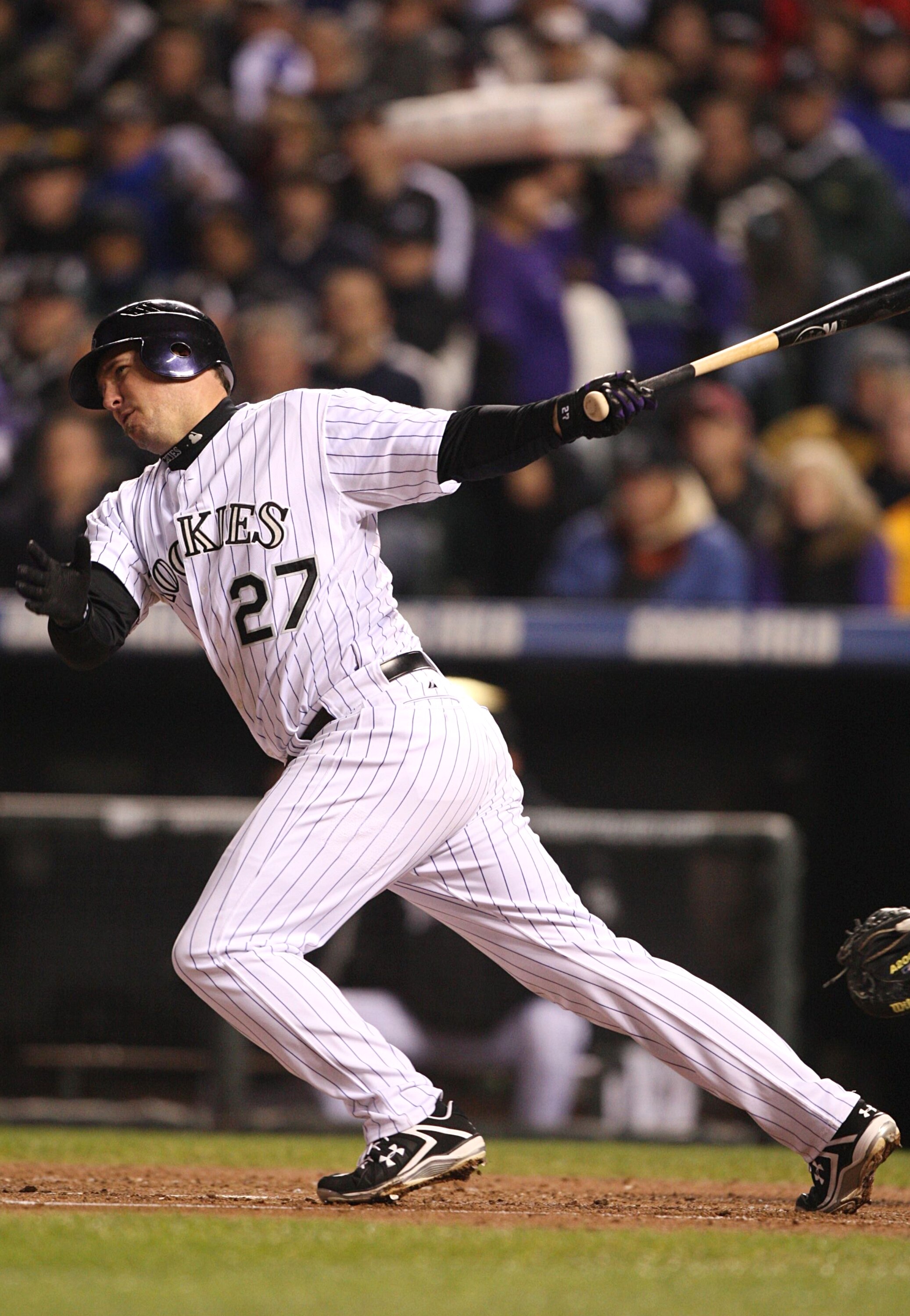 DENVER - OCTOBER 11:  Garrett Atkins #27 of the Colorado Rockies hits an rbi single against the Philadelphia Phillies in Game Three of the NLDS during the 2009 MLB Playoffs at Coors Field on October 11, 2009 in Denver, Colorado.  (Photo by Jed Jacobsohn/