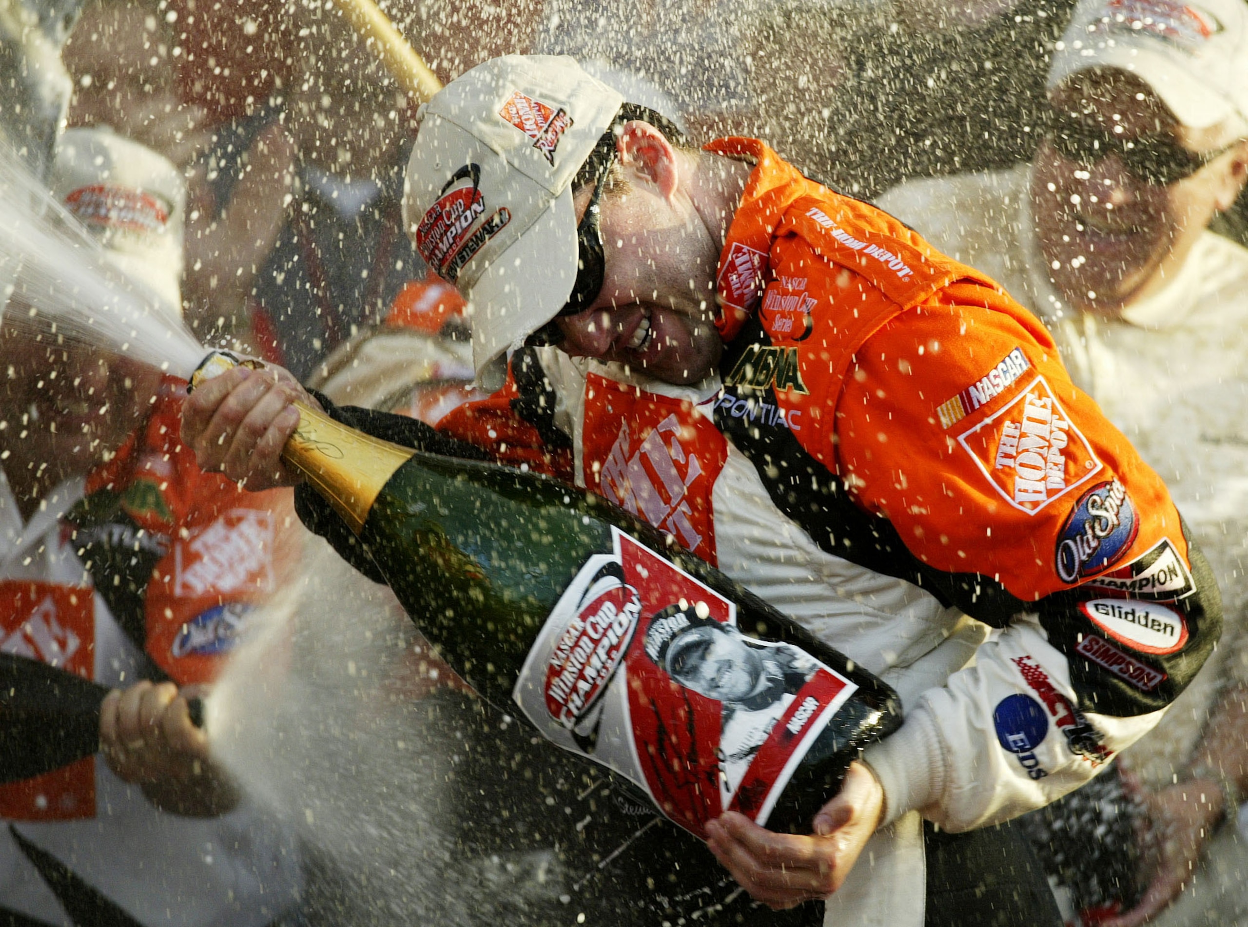 HOMESTEAD, FL - NOVEMBER 17:  Tony Stewart, driver of the #20 Home Depot Pontiac Grand Prix sprays champagne at his crew members in celebration after winning the NASCAR Winston Cup Championship at the NASCAR Winston Cup Series Ford 400 at the Homestead-Mi