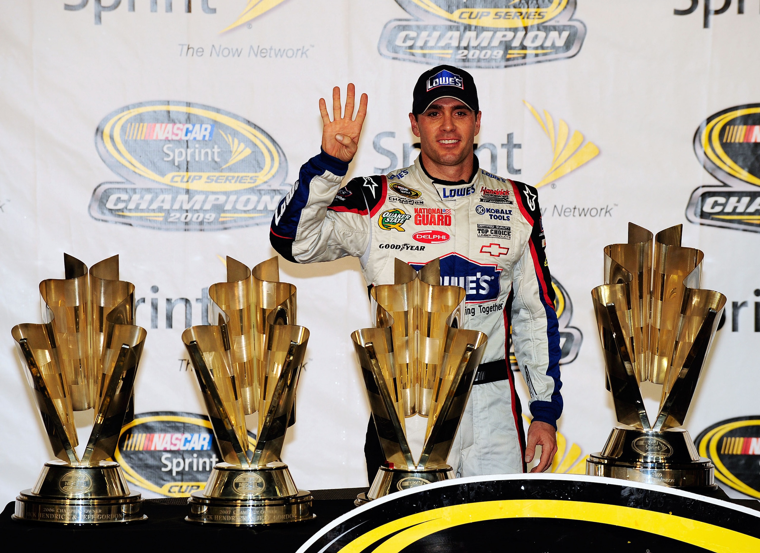 HOMESTEAD, FL - NOVEMBER 22:  Jimmie Johnson, driver of the #48 Lowe's Chevrolet, poses with all four of his championship trophies after winning the NASCAR Sprint Cup Series Championship at Homestead-Miami Speedway on November 22, 2009 in Homestead, Flori