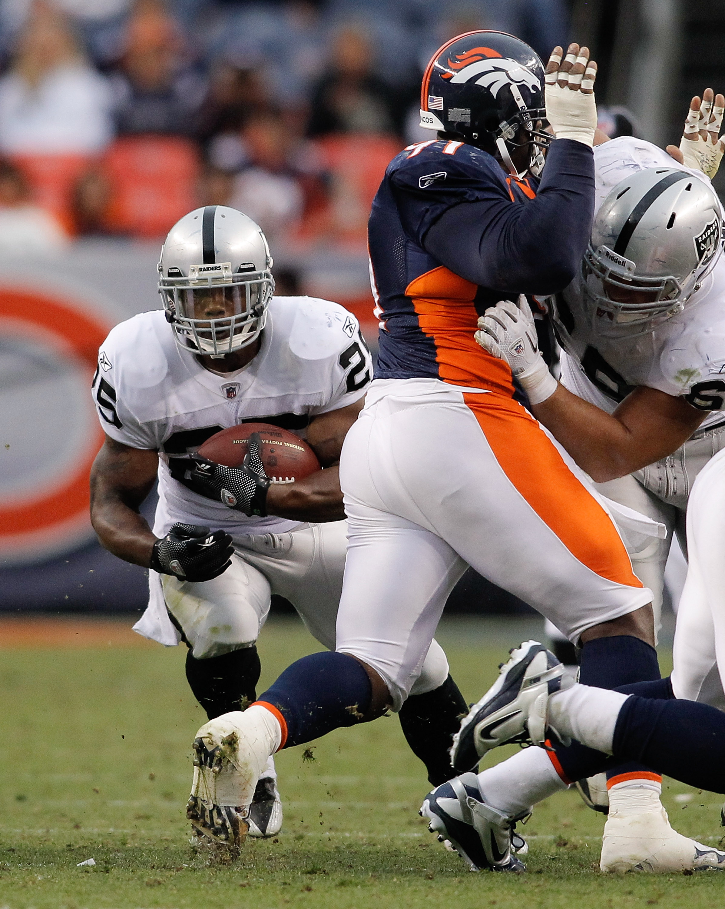 DENVER - OCTOBER 24:  Running back Michael Bush #25 of the Oakland Raiders runs through a hole in the fourth quarter against the Denver Broncos at INVESCO Field at Mile High on October 24, 2010 in Denver, Colorado. The Raiders defeated the Broncos 59-14. 