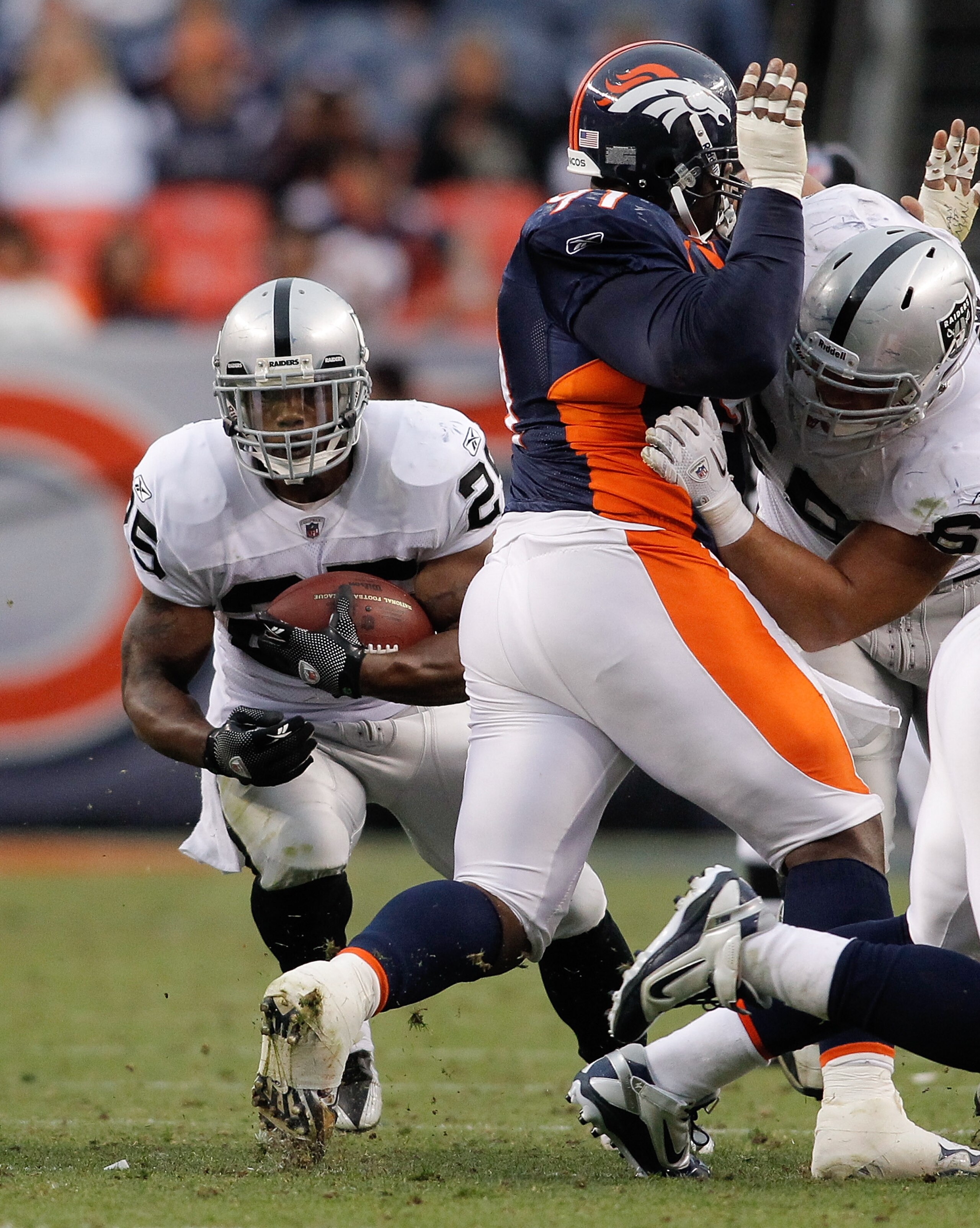 DENVER - OCTOBER 24:  Running back Michael Bush #25 of the Oakland Raiders runs through a hole in the fourth quarter against the Denver Broncos at INVESCO Field at Mile High on October 24, 2010 in Denver, Colorado. The Raiders defeated the Broncos 59-14. 