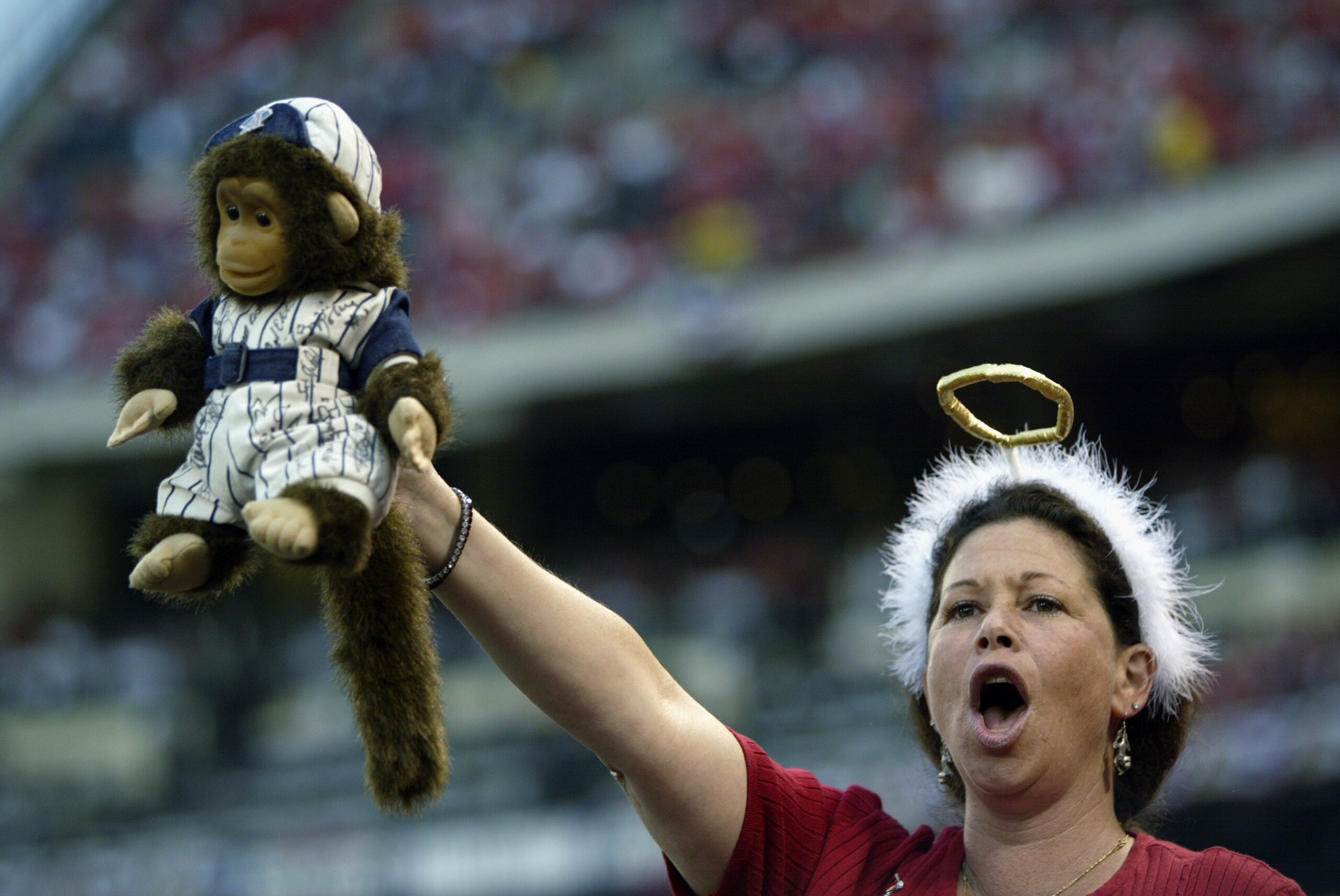 ANAHEIM, CA - OCTOBER 11:  A fan of the Anaheim Angels holds up a autographed 'rally monkey' stuffed animal during Game three of the American League Championship Series against the Minnesota Twins at Edison International Field on October 11, 2002 in Anahe