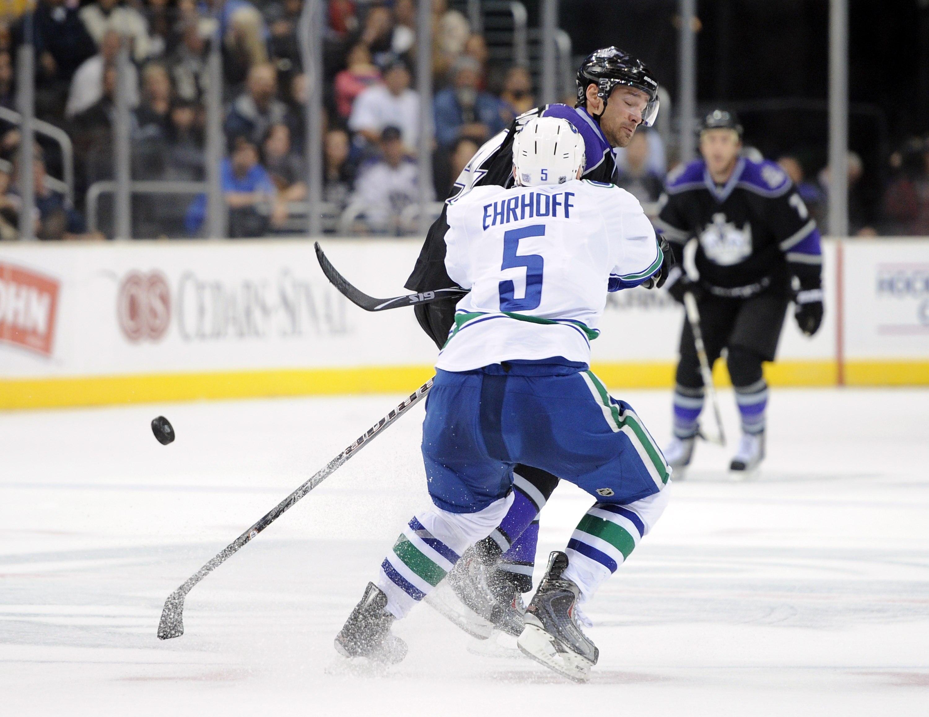 LOS ANGELES, CA - OCTOBER 15:  Justin Williams #14 of the Los Angeles Kings takes a check from Christian Ehrhoff #5 of the Vancouver Canucks at the Staples Center on October 15, 2010 in Los Angeles, California.  (Photo by Harry How/Getty Images)