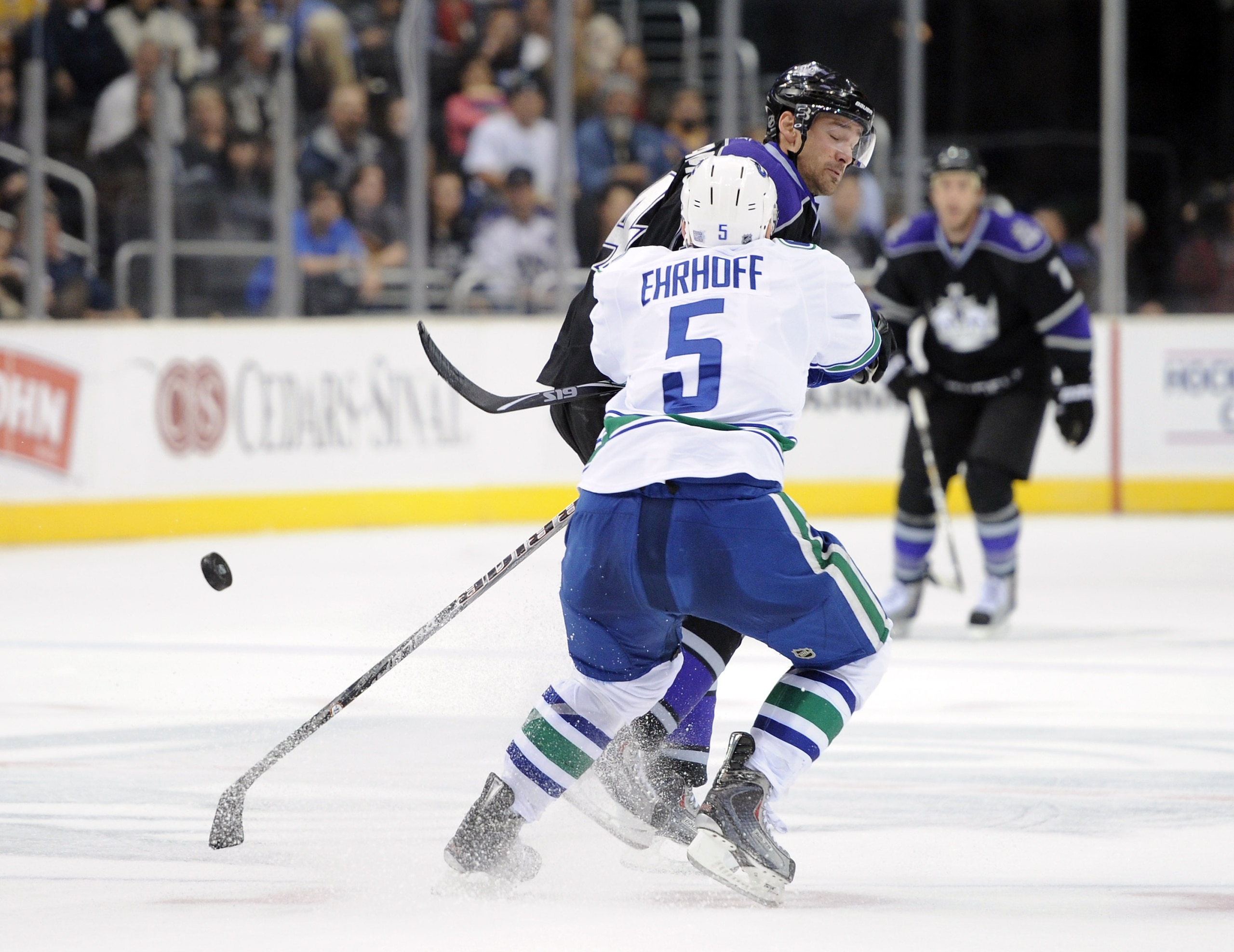 LOS ANGELES, CA - OCTOBER 15:  Justin Williams #14 of the Los Angeles Kings takes a check from Christian Ehrhoff #5 of the Vancouver Canucks at the Staples Center on October 15, 2010 in Los Angeles, California.  (Photo by Harry How/Getty Images)