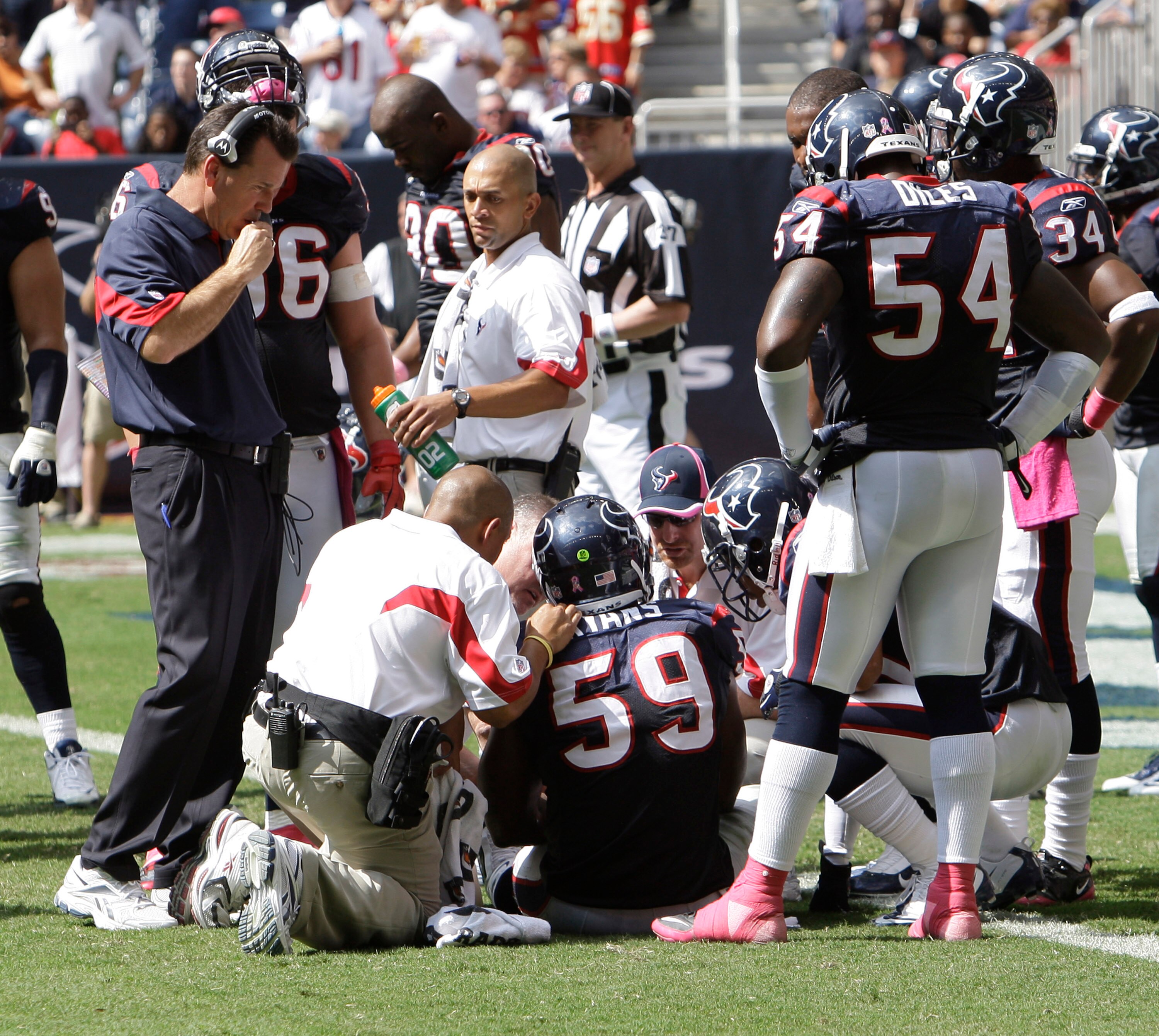 HOUSTON - OCTOBER 17:  DeMeco Ryans #59 of the Houston Texans is examined by medical staff as head coach Gary Kubiak looks on during a football game against the Kansas City Chiefs at Reliant Stadium on October 17, 2010 in Houston, Texas.  (Photo by Bob Le
