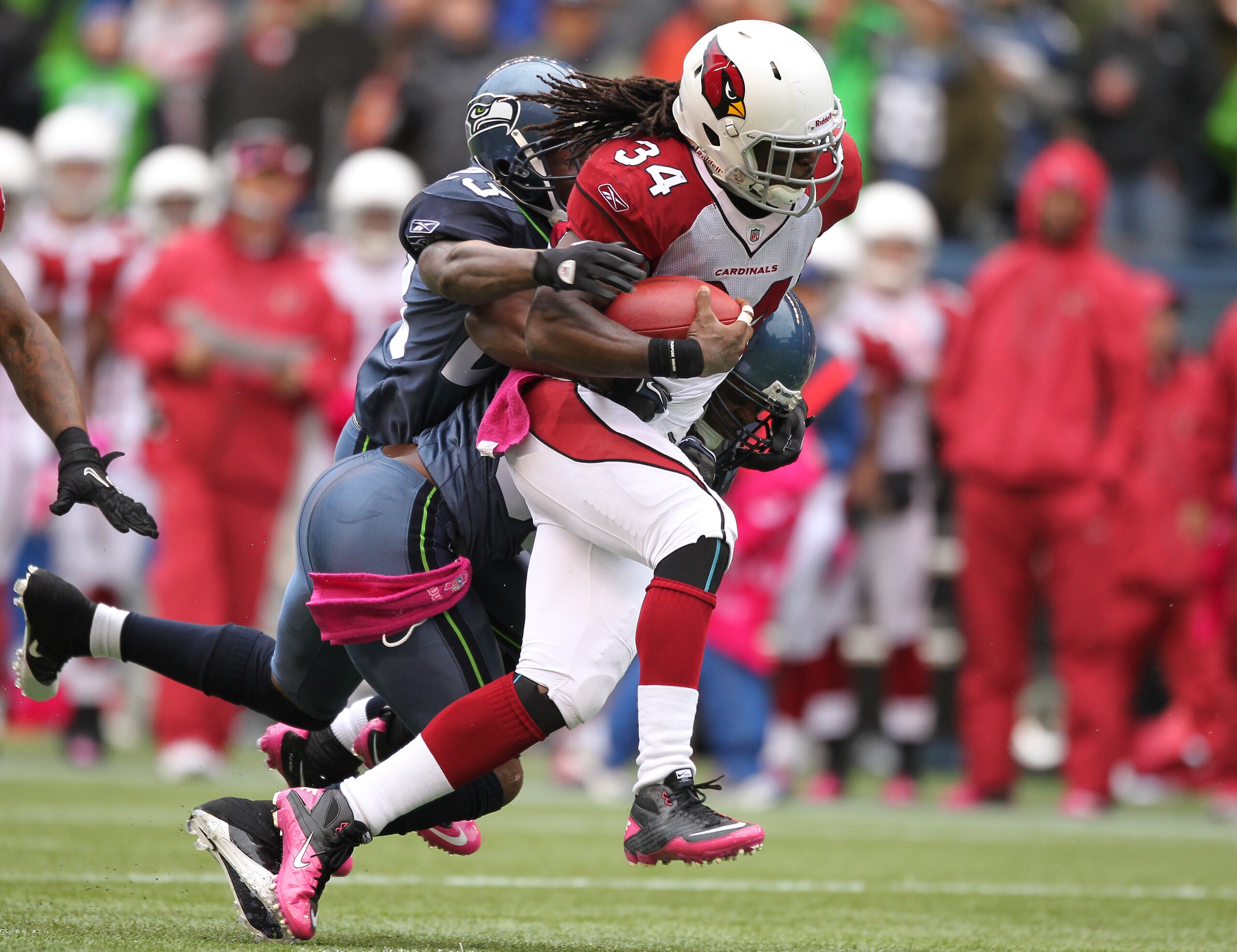 SEATTLE - OCTOBER 24:  Running back Tim Hightower #34 of the Arizona Cardinals rushes against Marcus Trufant #23 and Lawyer Milloy #36 of the Seattle Seahawks at Qwest Field on October 24, 2010 in Seattle, Washington. The Seahawks defeated the Cardinals 2