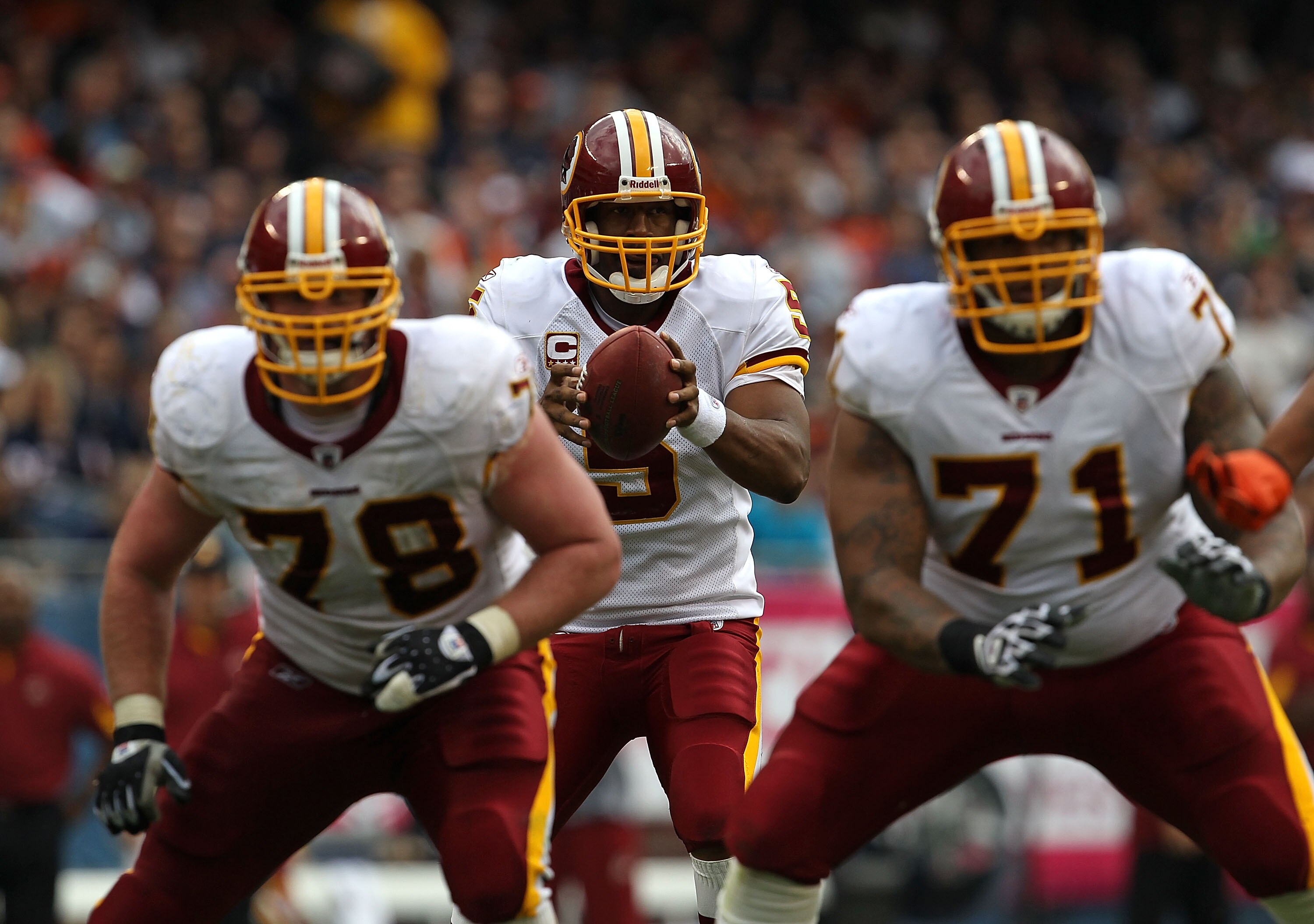 CHICAGO - OCTOBER 24: Donovan McNabb #5 of the Washington Redskins takes the snap against the Chicago Bears as teammates Kory Lichtensteiger #78 and Trent Williams #71 prepare to block at Soldier Field on October 24, 2010 in Chicago, Illinois. The Redskin