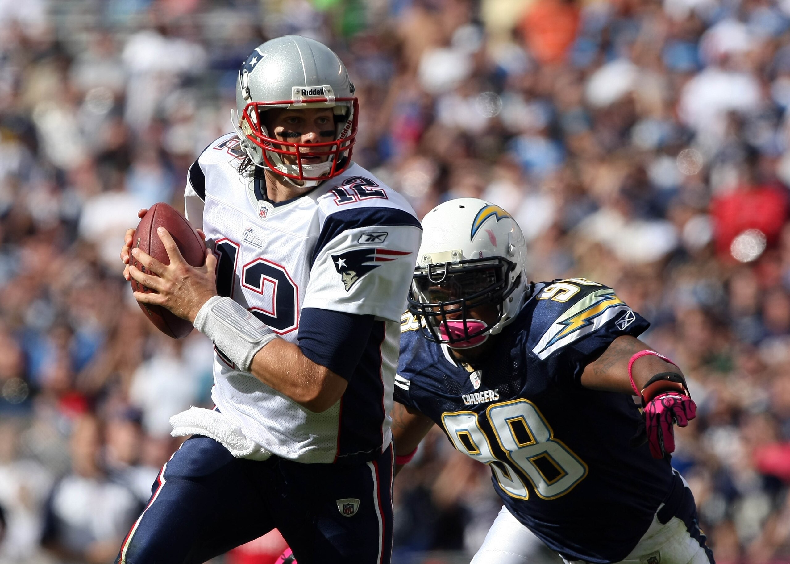 SAN DIEGO - OCTOBER 24:  Quarterback Tom Brady #12 of the New England scrambles with the ball against pressure from the pass rush of Antwan Barnes #98 of the San Diego Chargers during their NFL game on October 24, 2010 at Qualcomm Stadium in San Diego, Ca