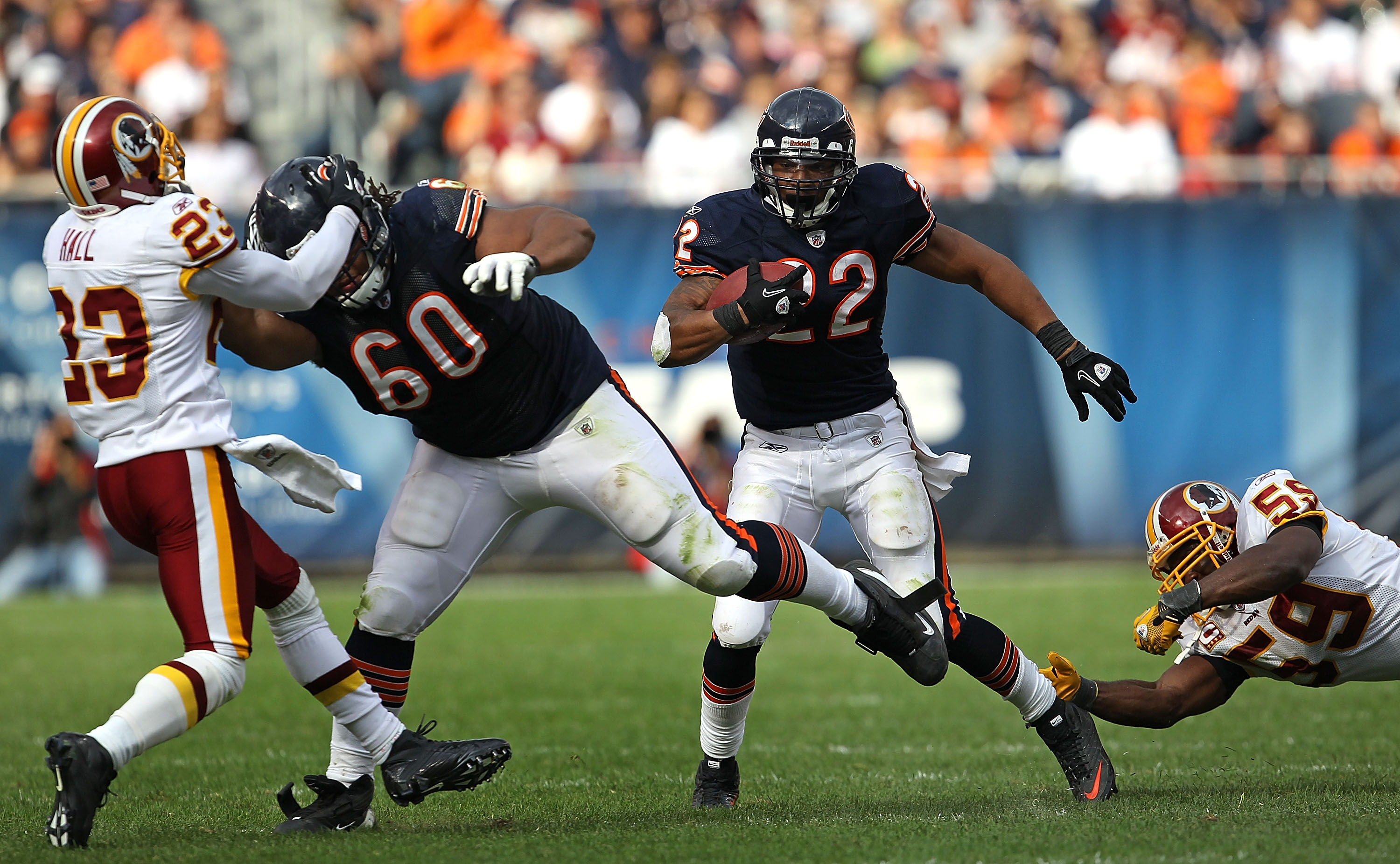 CHICAGO - OCTOBER 24: Matt Forte #22 of the Chicago Bears avoids a tackle attempt by London Fletcher #59 of the Washington Redskins as teammate Lance Louis #60 blocks DeAngelo Hall #23 at Soldier Field on October 24, 2010 in Chicago, Illinois. The Redskin