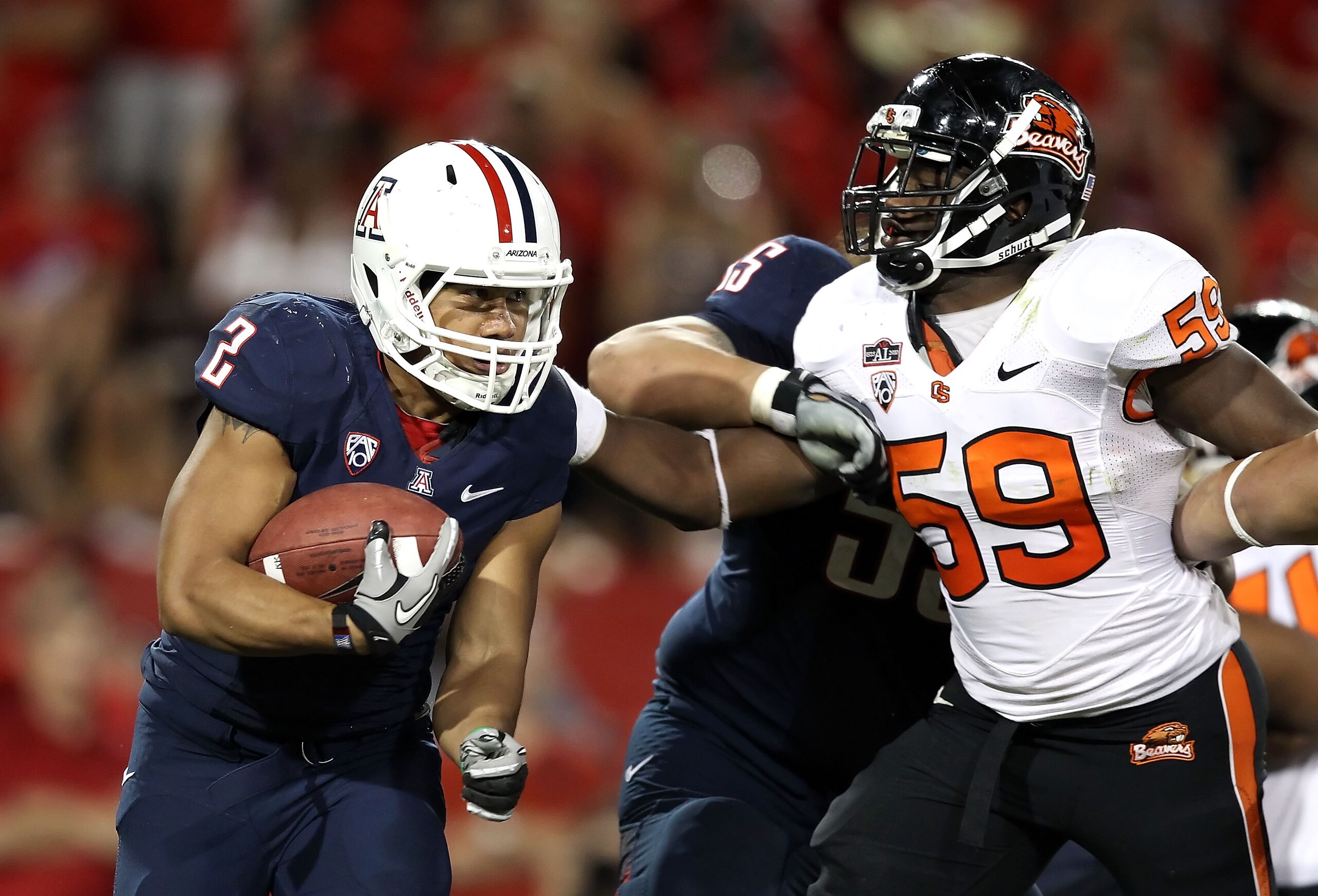 TUCSON, AZ - OCTOBER 09:  Runningback Keola Antolin #2 of the Arizona Wildcats rushes the football against Dwight Roberson #59 of the Oregon State Beavers during the college football game at Arizona Stadium on October 9, 2010 in Tucson, Arizona.  The Beav