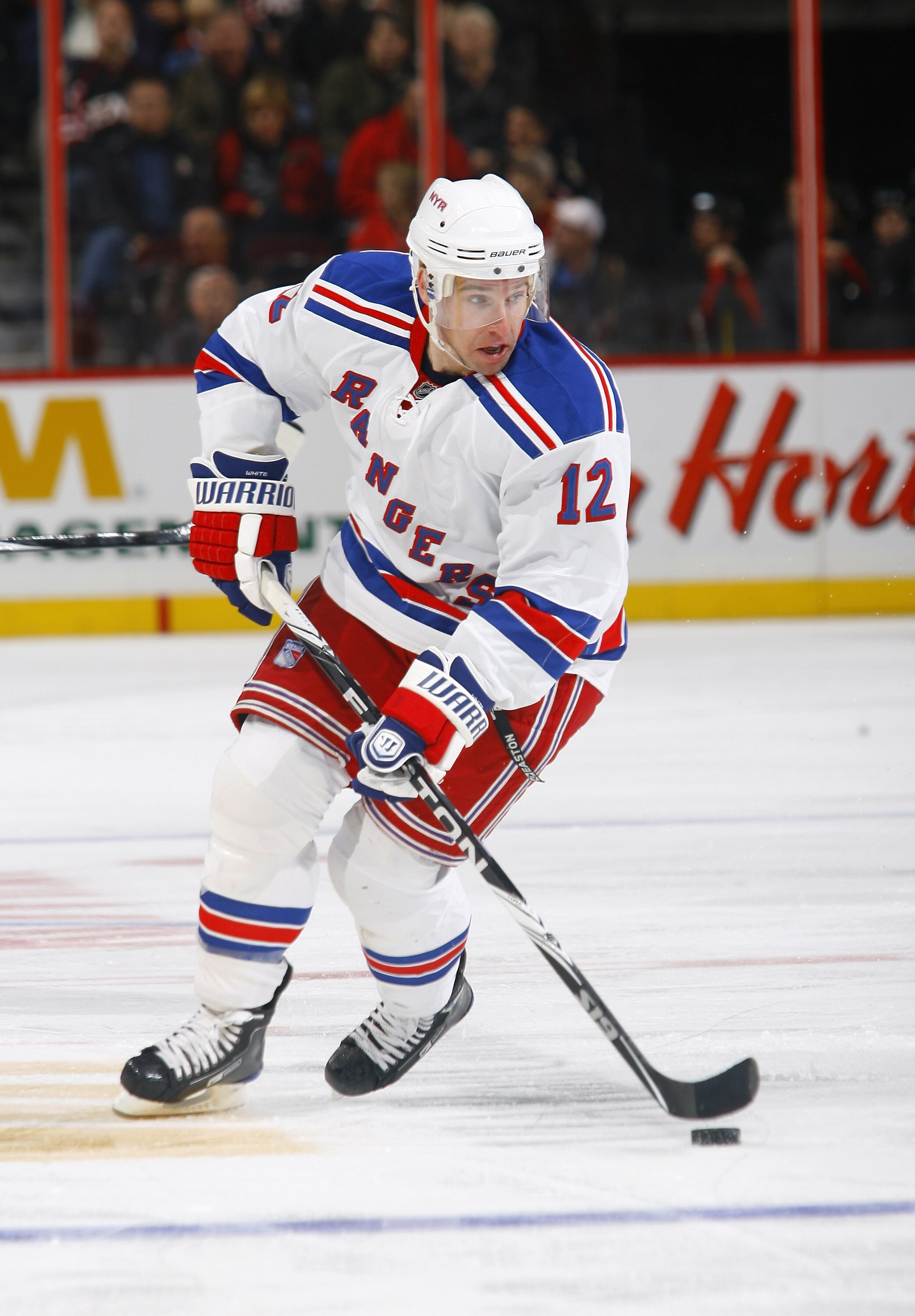 KANATA, ON - OCTOBER 02: Todd White #12 of the New York Rangers carries the puck up ice during a game against the Ottawa Senators at Scotiabank Place on October 2, 2010 in Kanata, Ontario, Canada.  The Ottawa Senators defeated the New York Rangers 8-5.  (