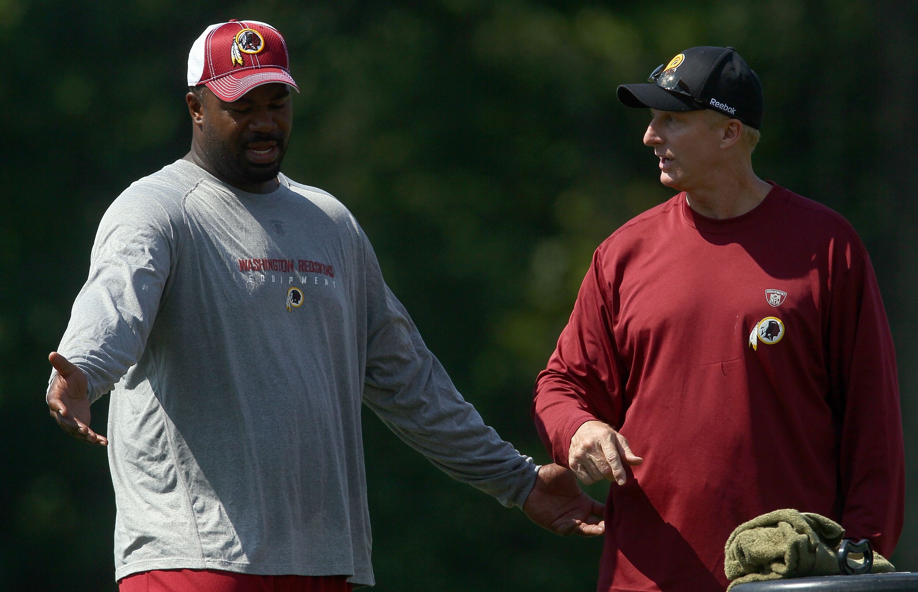 ASHBURN, VA - JULY 30:  Defensive lineman Albert Haynesworth #92 of the Washington Redskins works out with defensive coordinator Jim Haslett (R) following practice on the second day of training camp July 30, 2010 in Ashburn, Virginia. Haynesworth failed a
