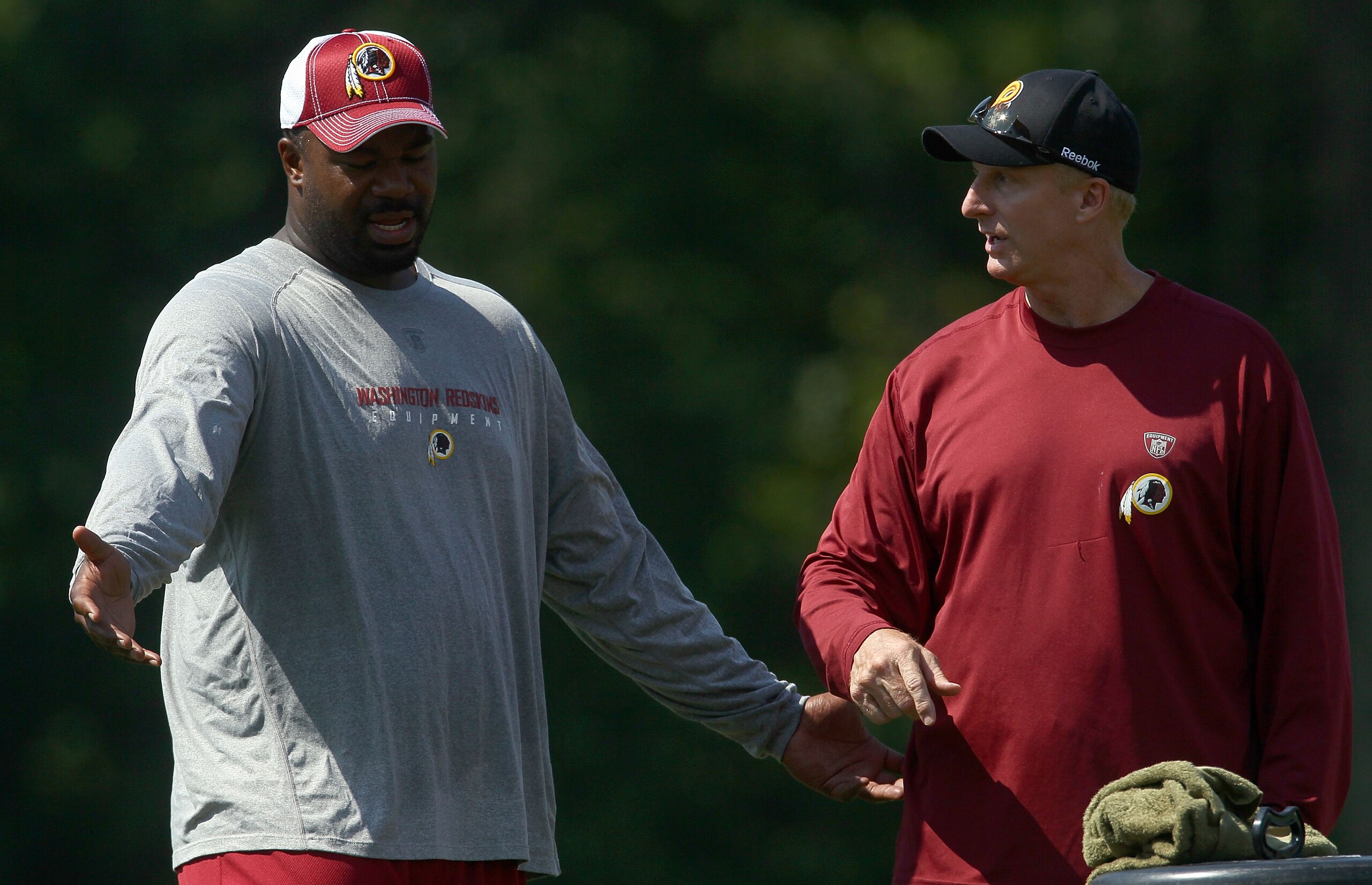 ASHBURN, VA - JULY 30:  Defensive lineman Albert Haynesworth #92 of the Washington Redskins works out with defensive coordinator Jim Haslett (R) following practice on the second day of training camp July 30, 2010 in Ashburn, Virginia. Haynesworth failed a