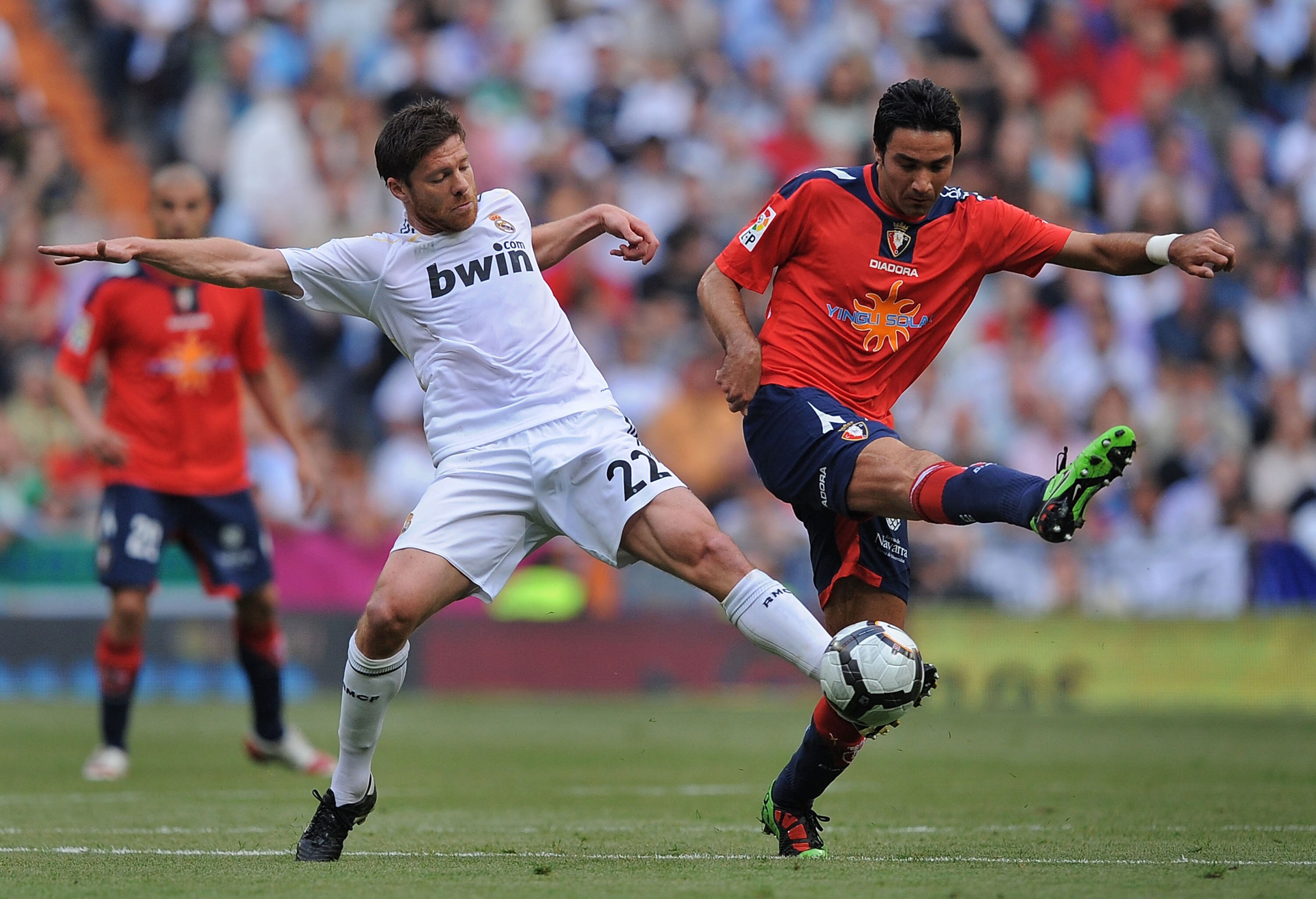 MADRID, SPAIN - MAY 02:  Xabi Alonso (L) of Real Madrid steals the ball from Javad Nekounam of CA Osasuna during the La Liga match between Real Madrid and CA Osasuna at Estadio Santiago Bernabeu on May 2, 2010 in Madrid, Spain.  (Photo by Denis Doyle/Gett