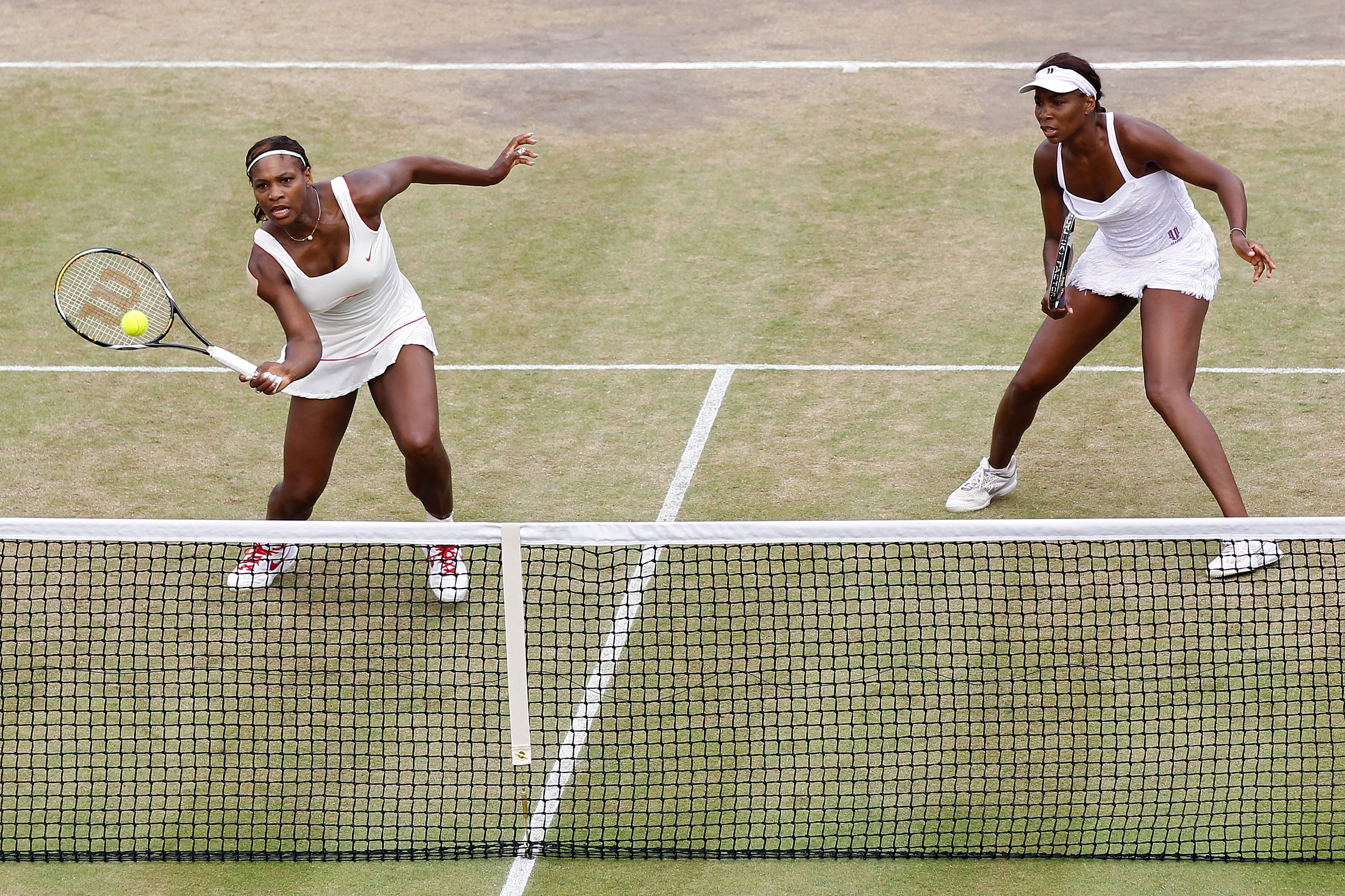 LONDON, ENGLAND - JUNE 30:  Serena Williams (L) and Venus Williams of USA in action during their Quarter Final doubles match against Elena Vesnina and Vera Zvonareva of Russia on Day Nine of the Wimbledon Lawn Tennis Championships at the All England Lawn