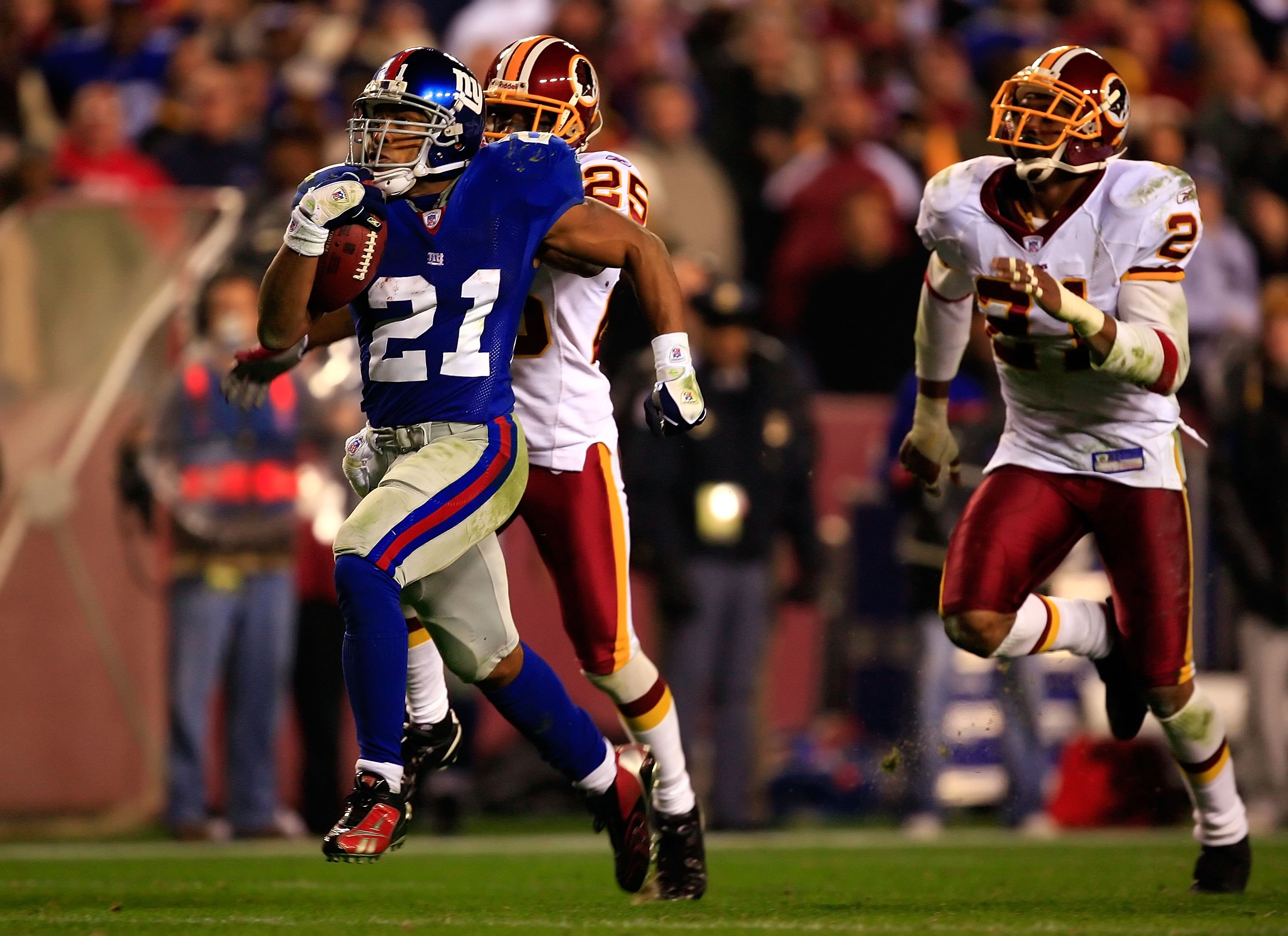 LANDOVER, MD - DECEMBER 30:  Tiki Barber #21 of the New York Giants runs the ball for his third touchdown against Kenny Wright #25 of the Washington Redskins at FedEx Field on December 30, 2006 in Landover, Maryland.  (Photo by Jamie Squire/Getty Images)