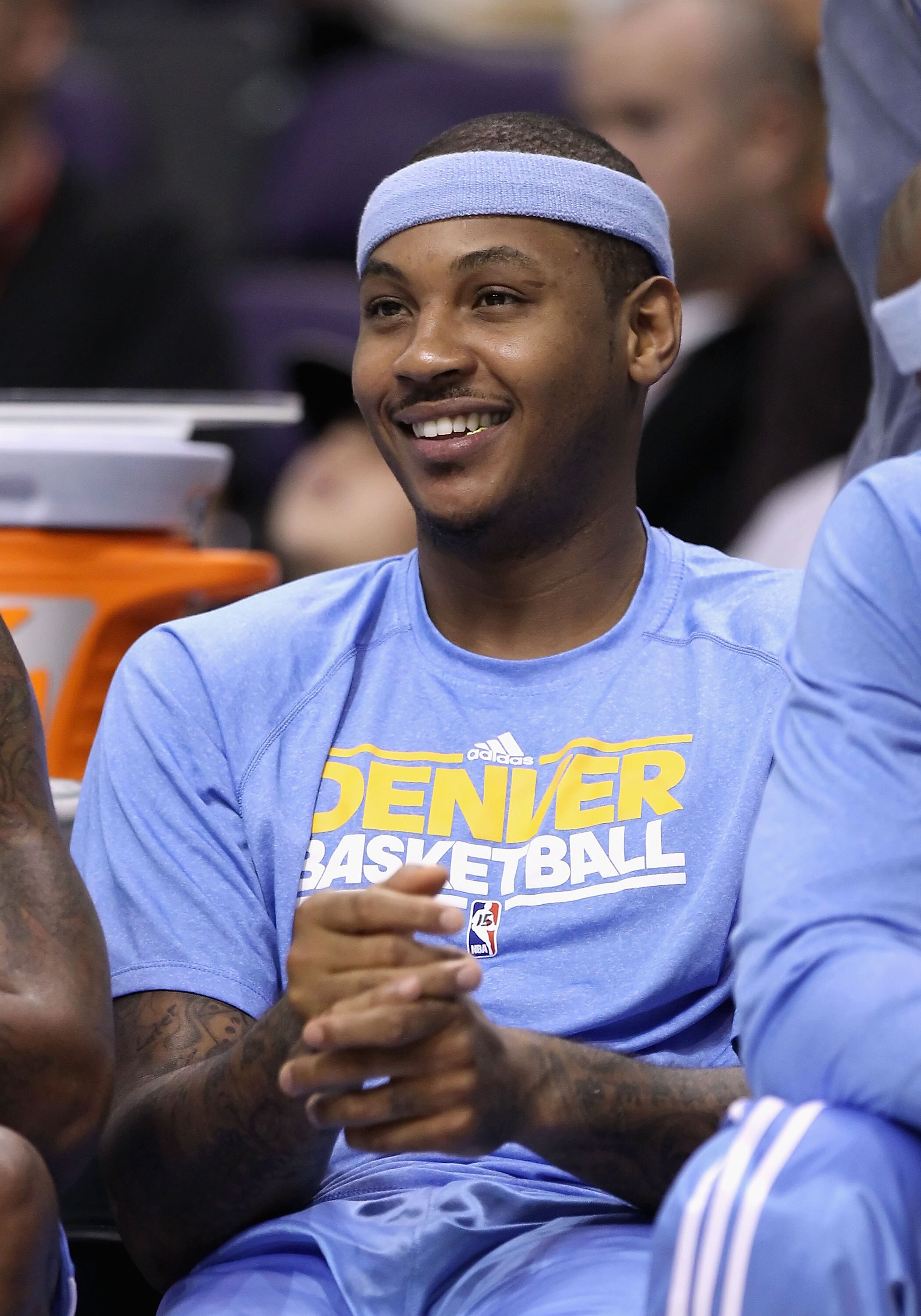 PHOENIX - OCTOBER 22:  Carmelo Anthony #15 of the Denver Nuggets smiles on the bench during the preseason NBA game against the Phoenix Suns at US Airways Center on October 22, 2010 in Phoenix, Arizona. NOTE TO USER: User expressly acknowledges and agrees