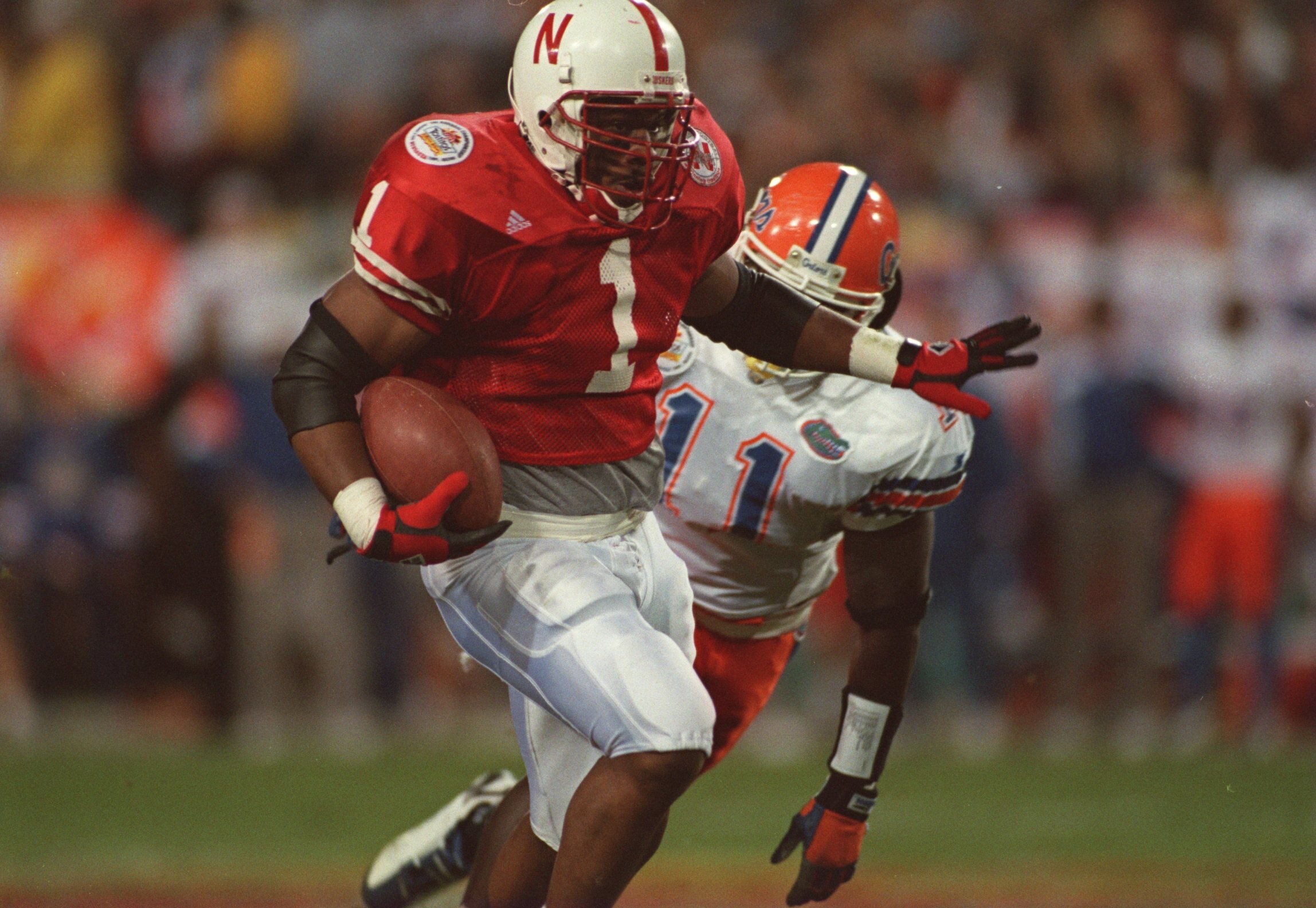 2 JAN 1996:  RUNNING BACK LAWRENCE PHILLIPS #1 OF THE NEBRASKA CORNHUSKERS AVOIDS DEFENSIVE BACK BEN HANKS #11 OF THE FLORIDA GATORS DURING THE FIESTA BOWL AT SUN DEVIL STADIUM IN TEMPE, ARIZONA.   Mandatory Credit: Mike Powell/ALLSPORT