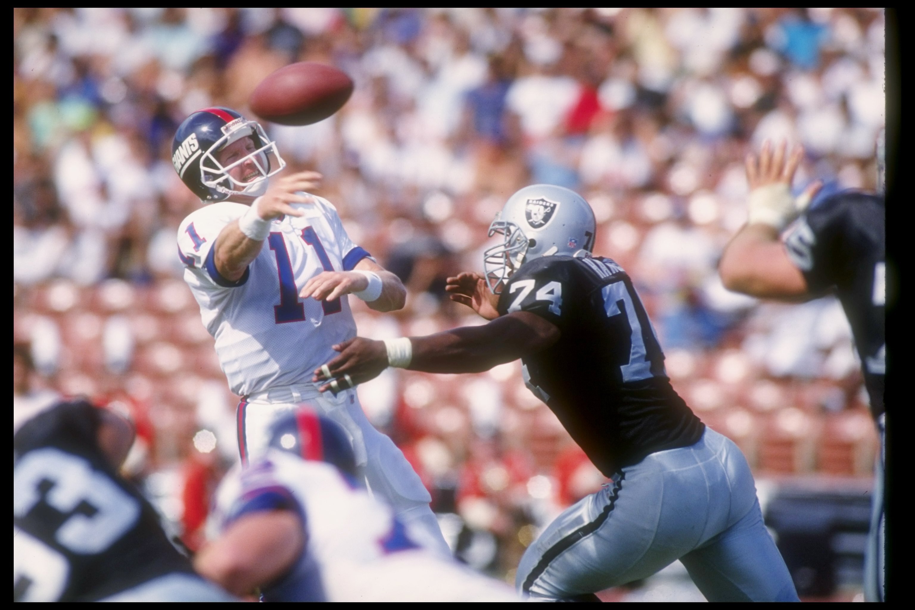 4 Oct 1992:  Quarterback Phil Simms of the New York Giants (left) passes the ball during a game against the Los Angeles Raiders at the Los Angeles Memorial Coliseum in Los Angeles, California.  The Raiders won the game, 13-10. Mandatory Credit: Stephen Du