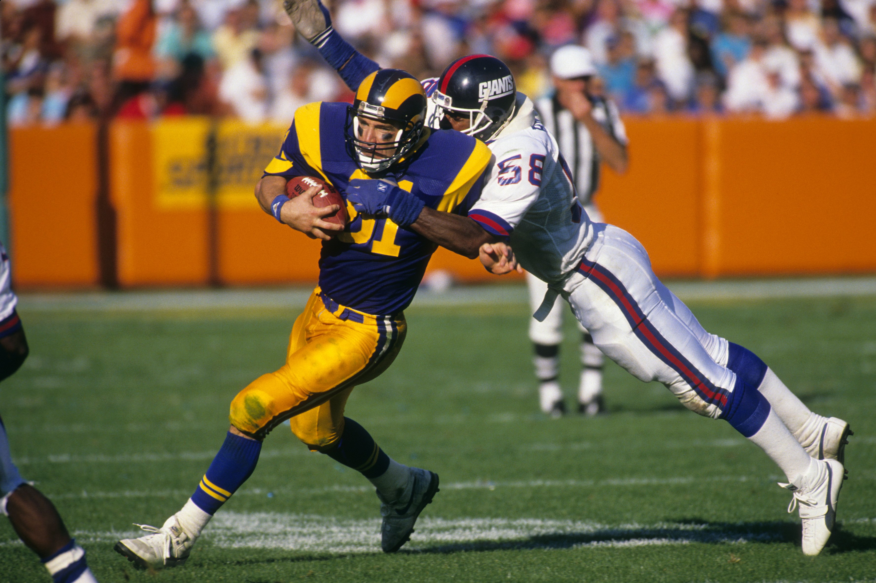 ANAHEIM, CA - NOVEMBER 12:  Tight end Pete Holohan #81 of the Los Angeles Rams tries to break a tackle by  linebacker Carl Banks #58 of the New York Giants during the game at Anaheim Stadium on November 12, 1989 in Anaheim, California. The Rams won 31-10.