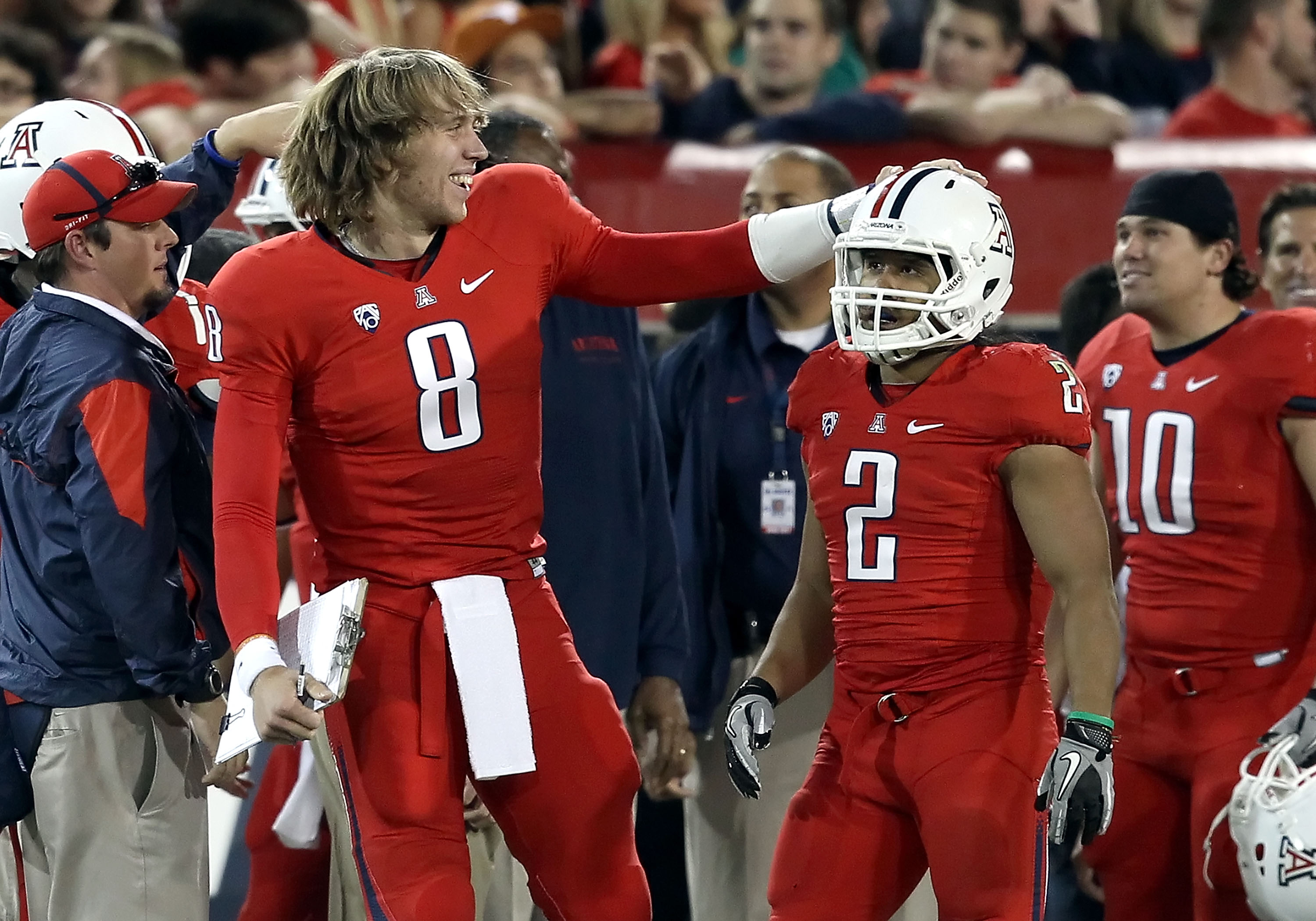 TUCSON, AZ - OCTOBER 23: Injured quarterback Nick Foles #8 of the Arizona Wildcats congratulates Keola Antolin #2 after Antolin scored a 78 yard rushing touchdown against the Washington Huskies during the second quarter of the college football game at Ar TUCSON, AZ - OCTOBER 23: Injured quarterback Nick Foles #8 of the Arizona Wildcats congratulates Keola Antolin #2 after Antolin scored a 78 yard rushing touchdown against the Washington Huskies during the second quarter of the college football game at Ar