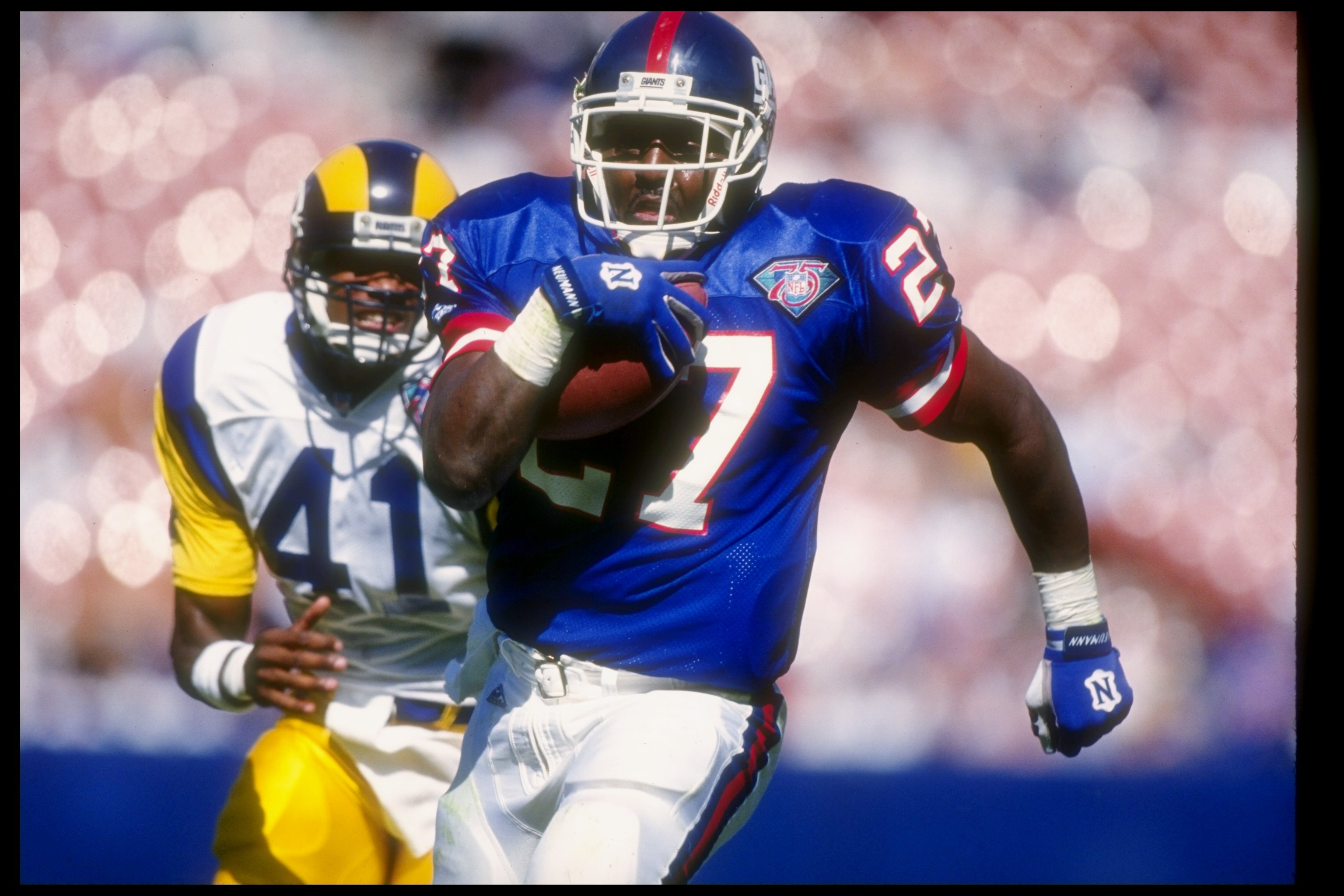 16 Oct 1994:  Running back Rodney Hampton of the New York Giants   (right) moves the ball as Los Angeles Rams defensive back Todd Lyght chases him during a game at Anaheim Stadium in Anaheim, California.  The Rams won the game, 17-10. Mandatory Credit: Al