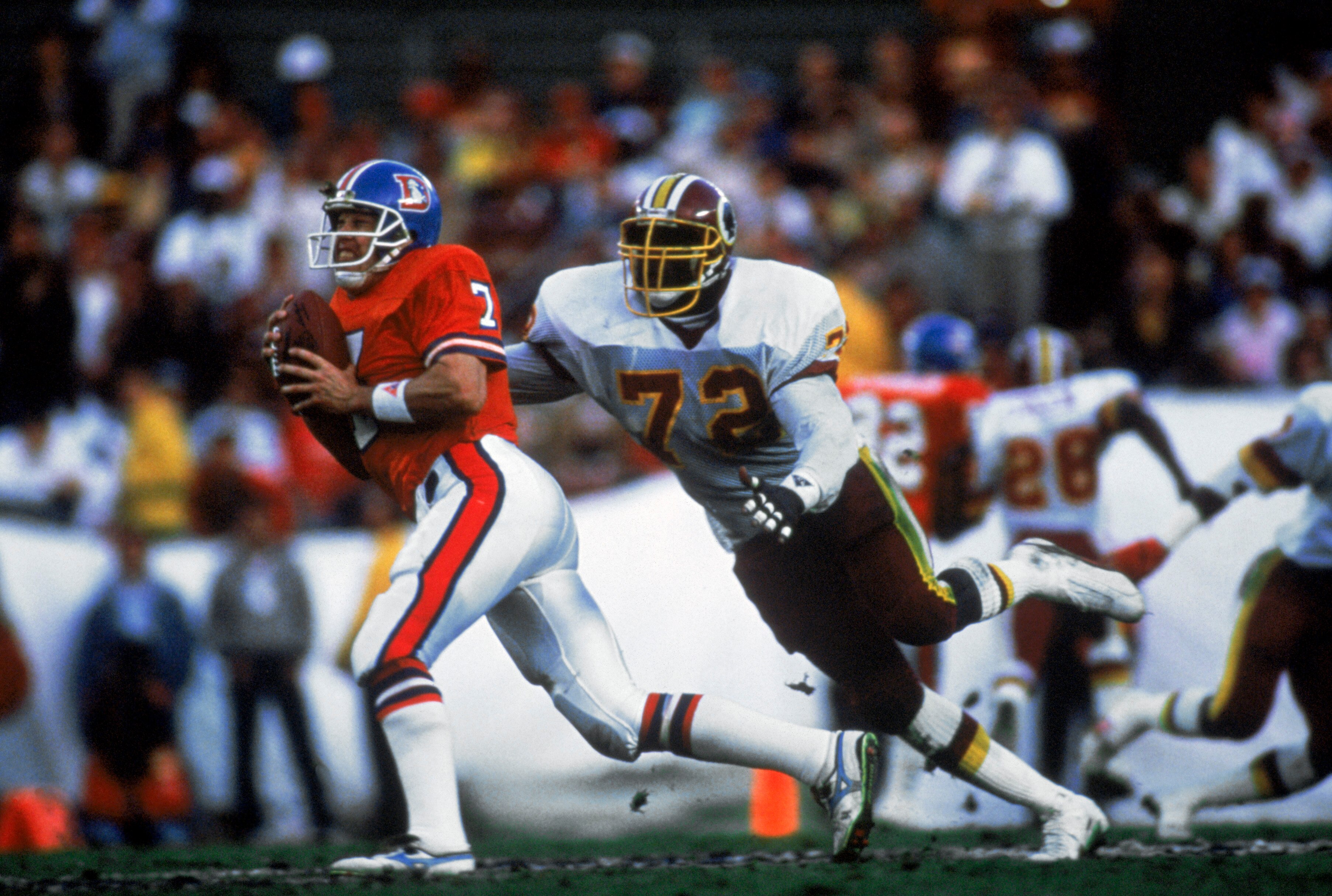 SAN DIEGO - JANUARY 31:  Quarterback John Elway #7 of the Denver Broncos tries to avoid an onrushing Dexter Manley #72 of the Washington Redskins during Superbowl XXII on January 31, 1988 at San Diego Jack Murphy Stadium in San Diego, California.  The Red