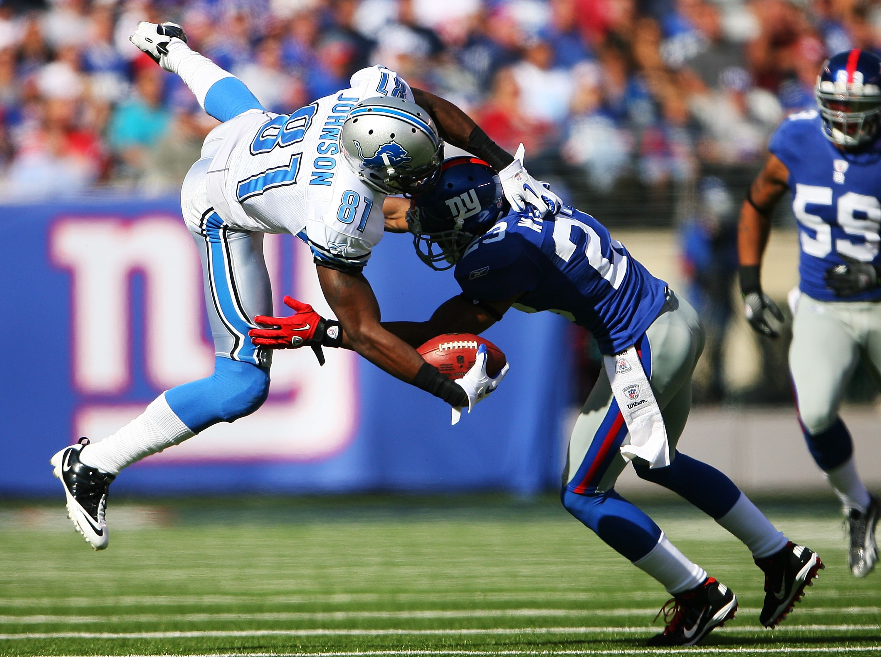 EAST RUTHERFORD, NJ - OCTOBER 17:  Calvin Johnson #81 of the Detroit Lions completes a first down in the second quarter while Corey Webster #23 of the New York Giants tackles him at New Meadowlands Stadium on October 17, 2010 in East Rutherford, New Jerse