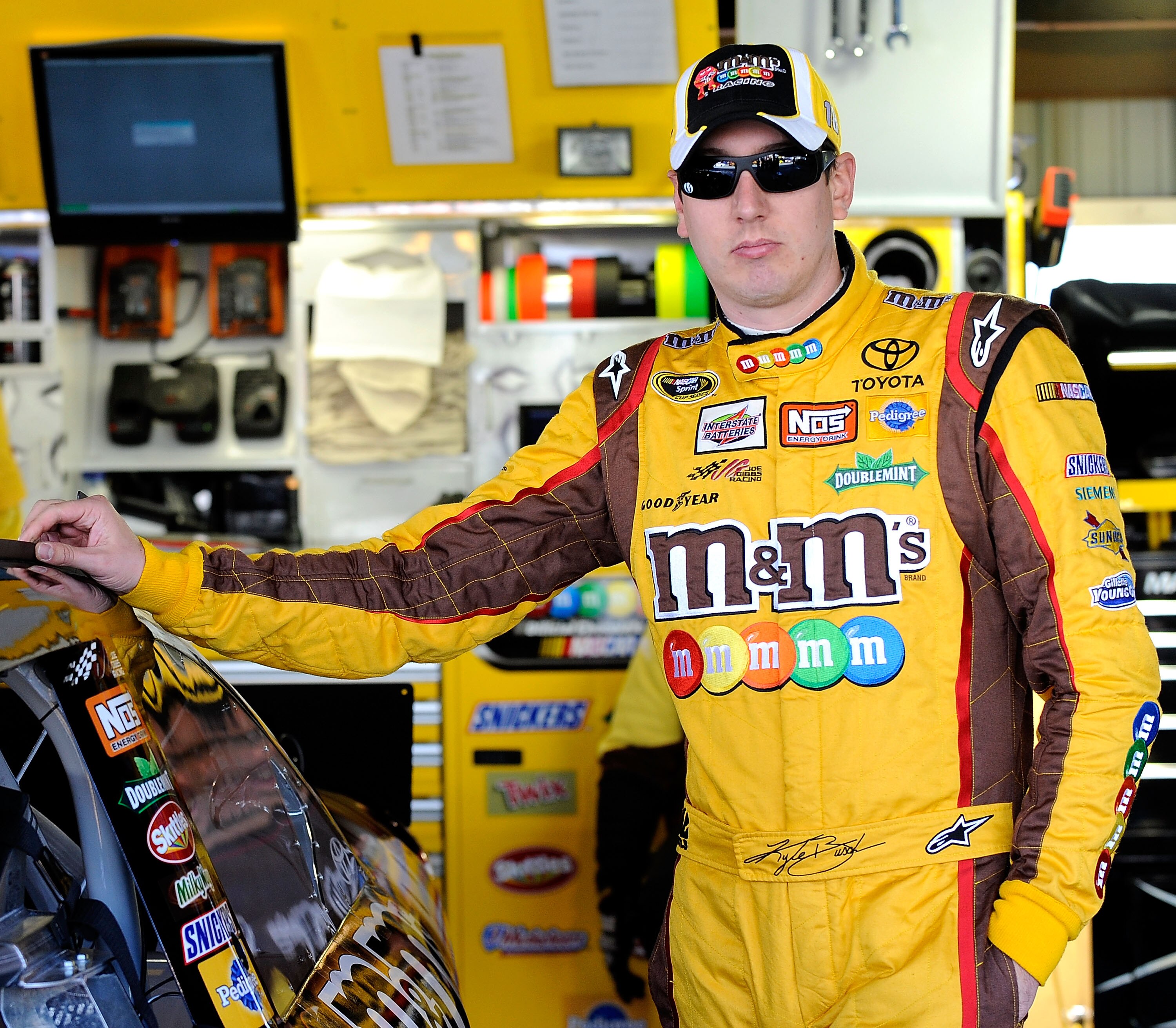 MARTINSVILLE, VA - OCTOBER 22:  Kyle Busch, driver of the #18 M&M's Toyota, stands in the garage prior to practice for the NASCAR Sprint Cup Series TUMS Fast Relief 500 at Martinsville Speedway on October 22, 2010 in Martinsville, Virginia.  (Photo by Rus